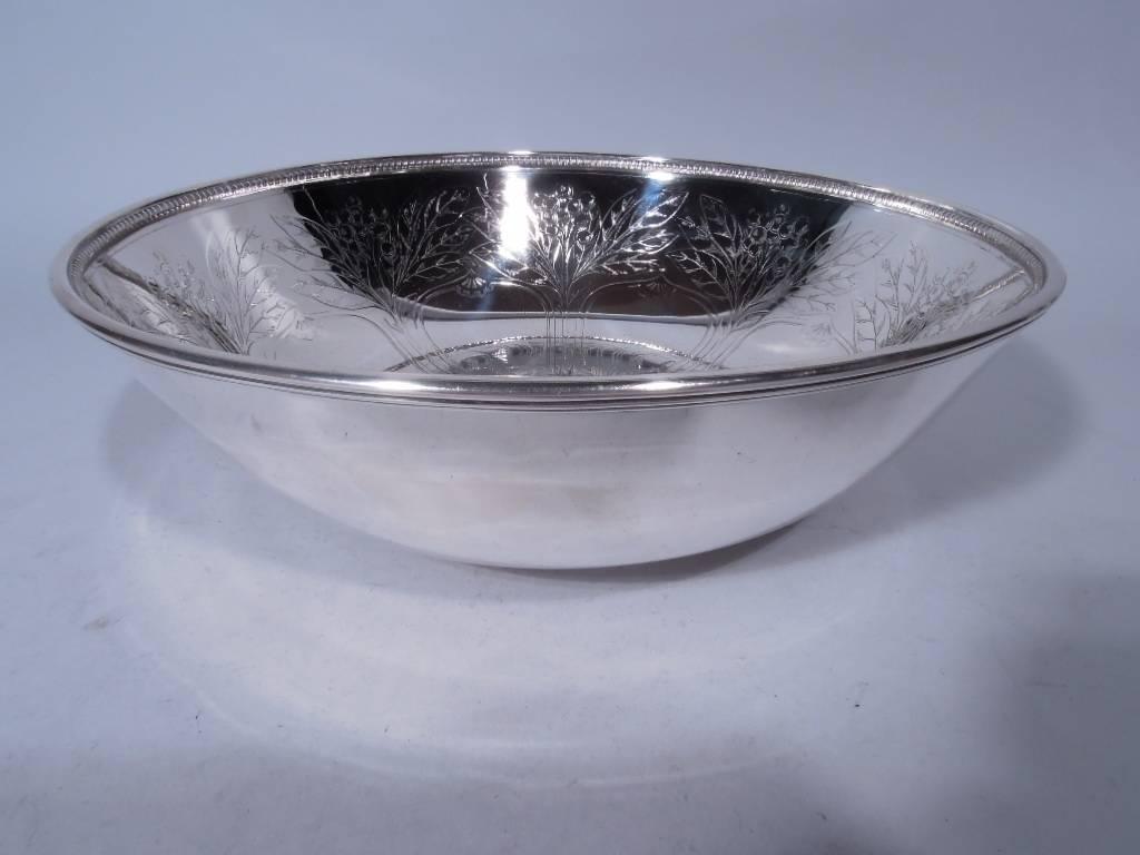 Sterling silver bowl. Made by Tiffany & Co in New York, circa 1907. Curved sides and short foot. Interior has engraved fruit trees rooted in central multifoil frame (vacant). An unusual design rich in symbolic possibilities. Raised bead-and-reel