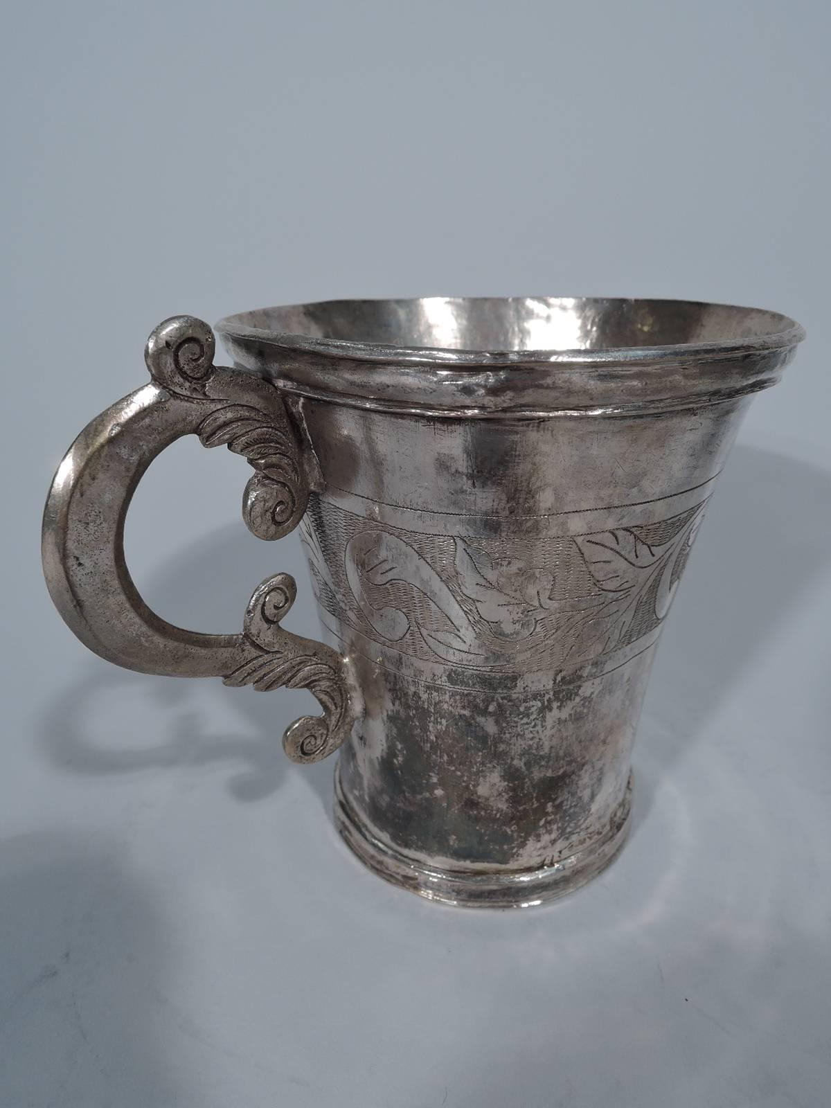 Good antique silver mug from South America, circa 1840. Tapering sides and flared rim. Engraved band of scrolls and flowers. S-scroll handle with worked leaves. Flared shape with worked handle. Condition: Nice old patina and character-enhancing