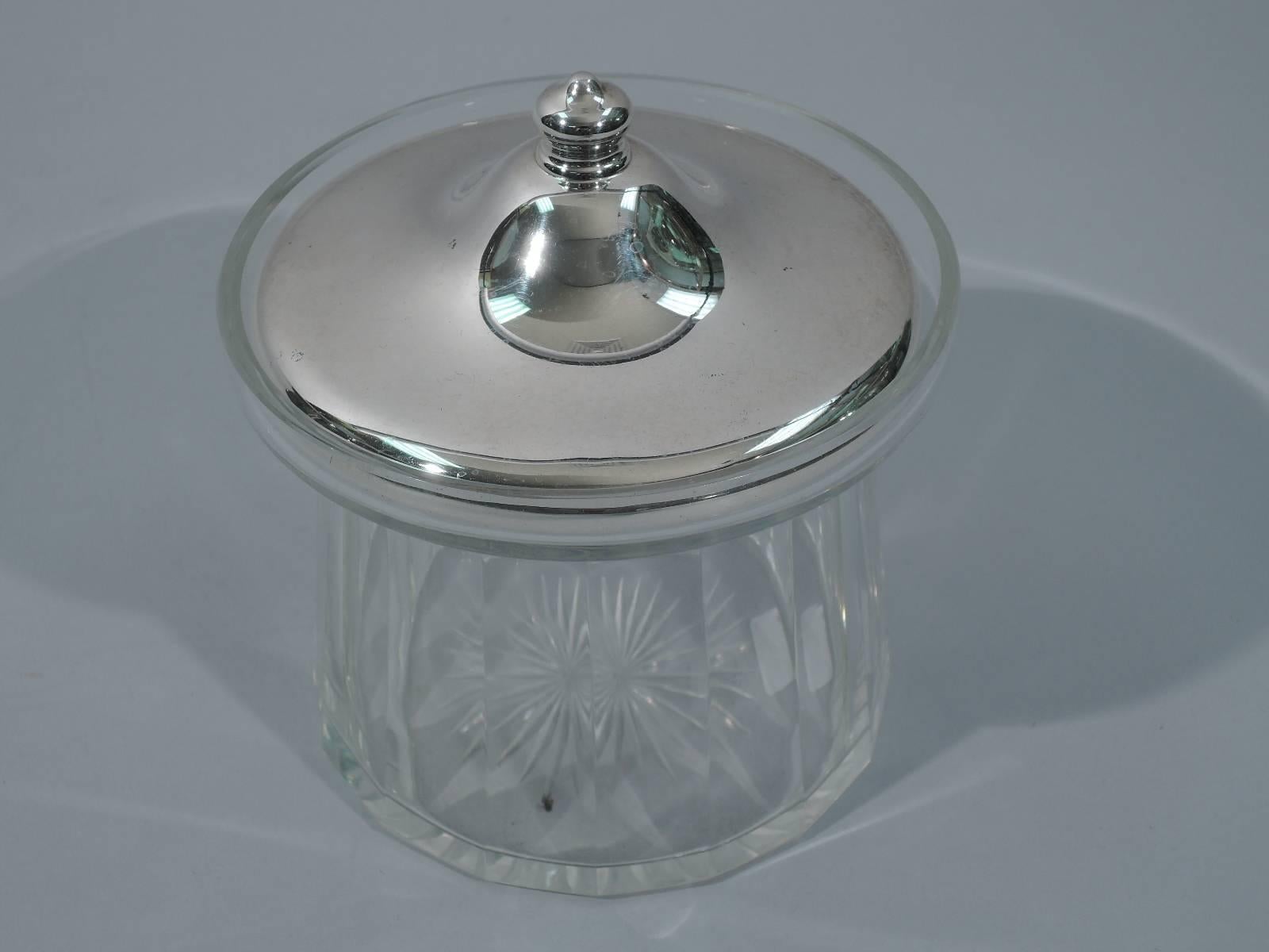 Clear glass jam jar with sterling silver cover. Made by R. Wallace & Sons in Wallingford, circa 1920. Round with fluted and upward tapering sides and short overhanging rim. Raised pavilion-form cover with finial. Cover interior gilt. Hallmark