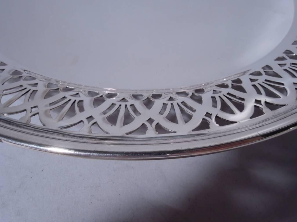 Sterling silver cake plate. Made by Tiffany & Co. in New York, circa 1914. Solid well bordered by pierced and interlacing arcade. Short and stepped support. Hallmark includes pattern no. 18678C (first produced in 1914) and director’s letter m