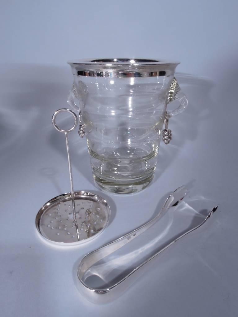 Danish Modern sterling silver and clear glass ice bucket. Made by Hugo Grün & Co. in Copenhagen, circa 1960. Tapering sides with interior horizontal lobing. Fluted scroll side handles with scallop shell mounts. Each handle has with loose ring with