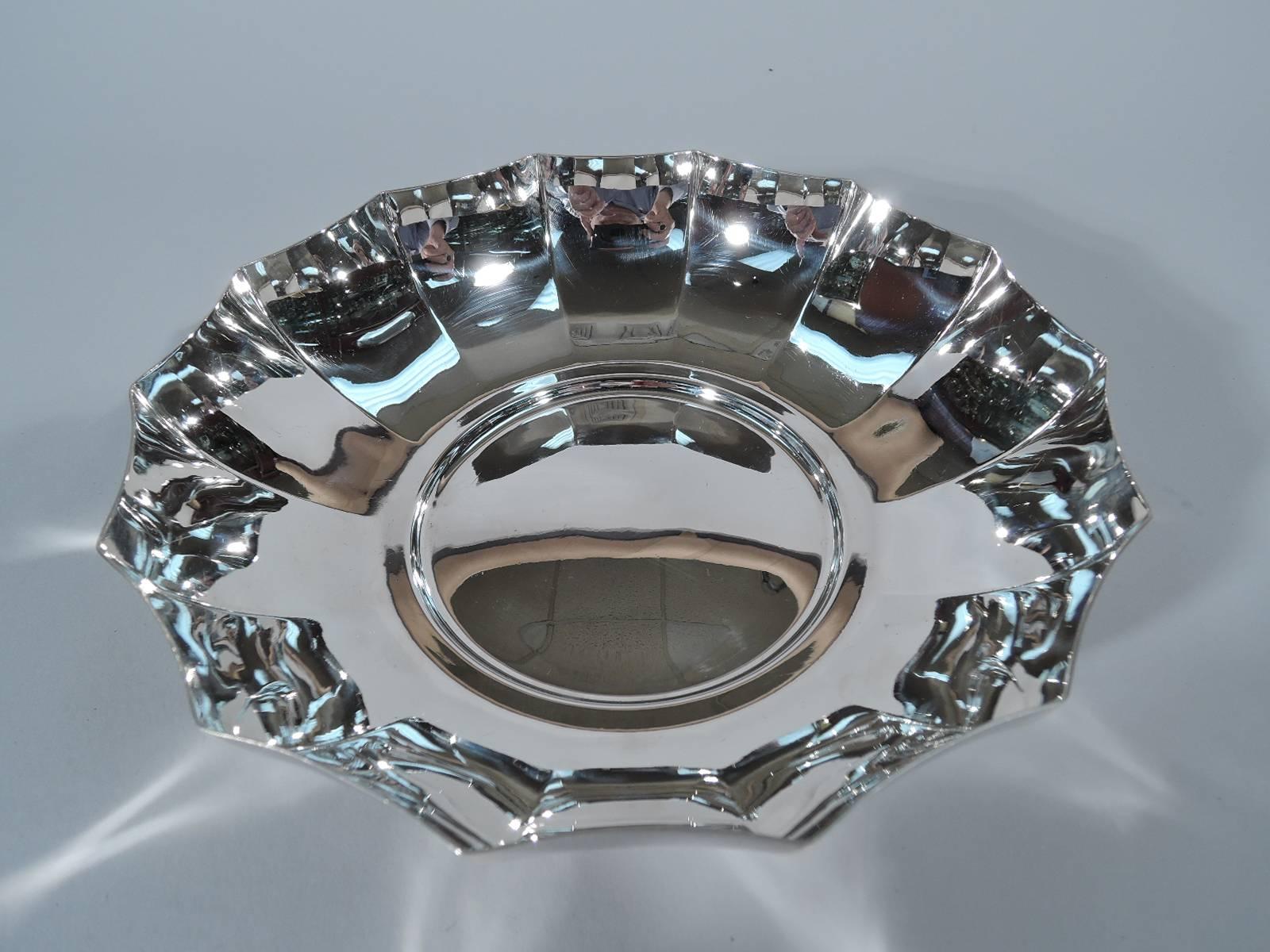 Sterling silver bowl. Made by Tiffany & Co. in New York. Curved and faceted sides and circular well. A fine Midcentury design. Hallmark includes postwar pattern no. 23570. Very good condition.

Dimensions: H 1 7/8 x W7 3/8 x D 7 in. Weight: 9.3