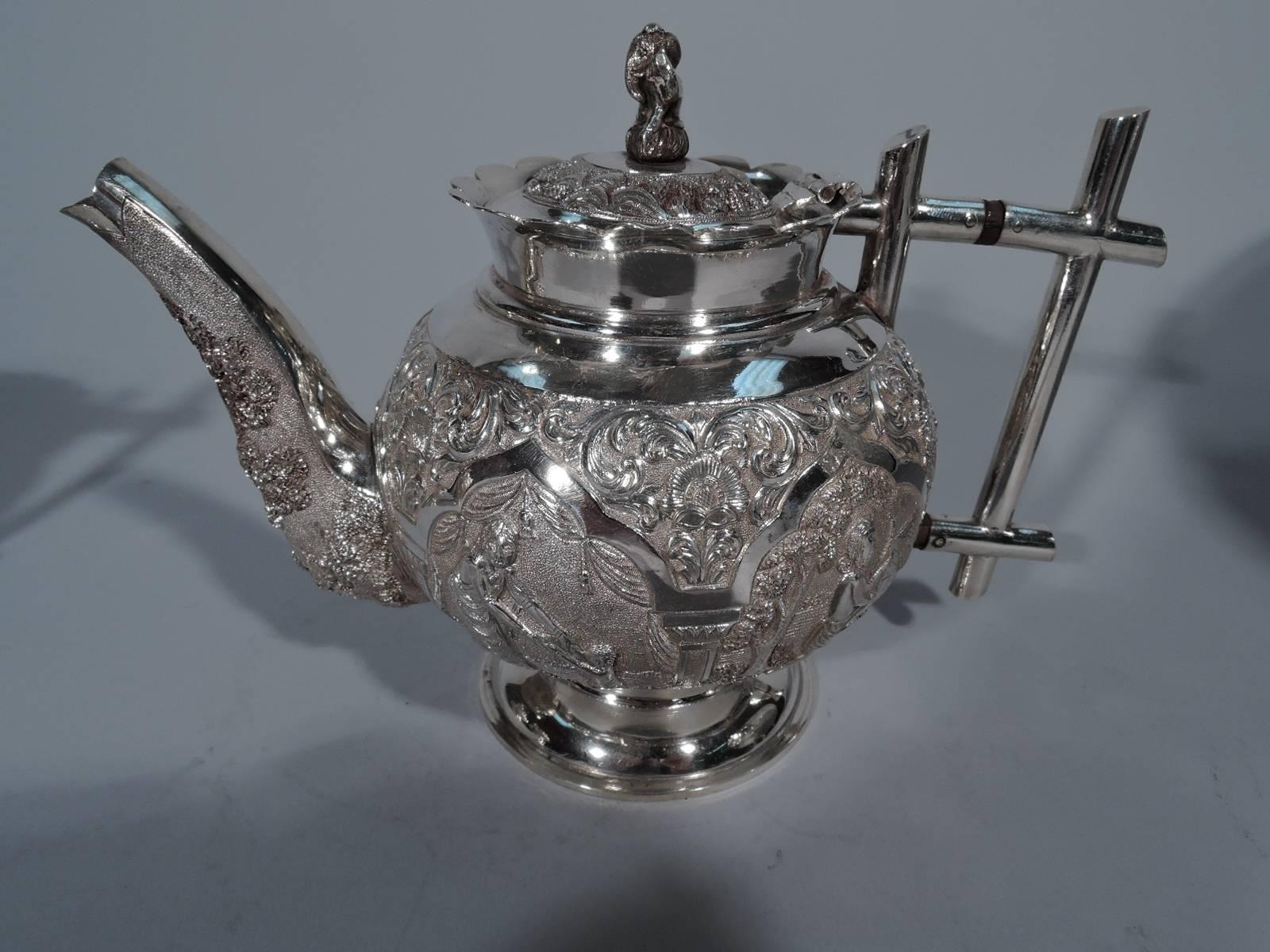 Colonial Indian silver tea set, circa 1900. This set comprises teapot, creamer and sugar.

Each: Globular with scalloped rim and stepped foot. Handles rectilinear brackets. Teapot has finial in form of elephant seated in lotus position. Decorated