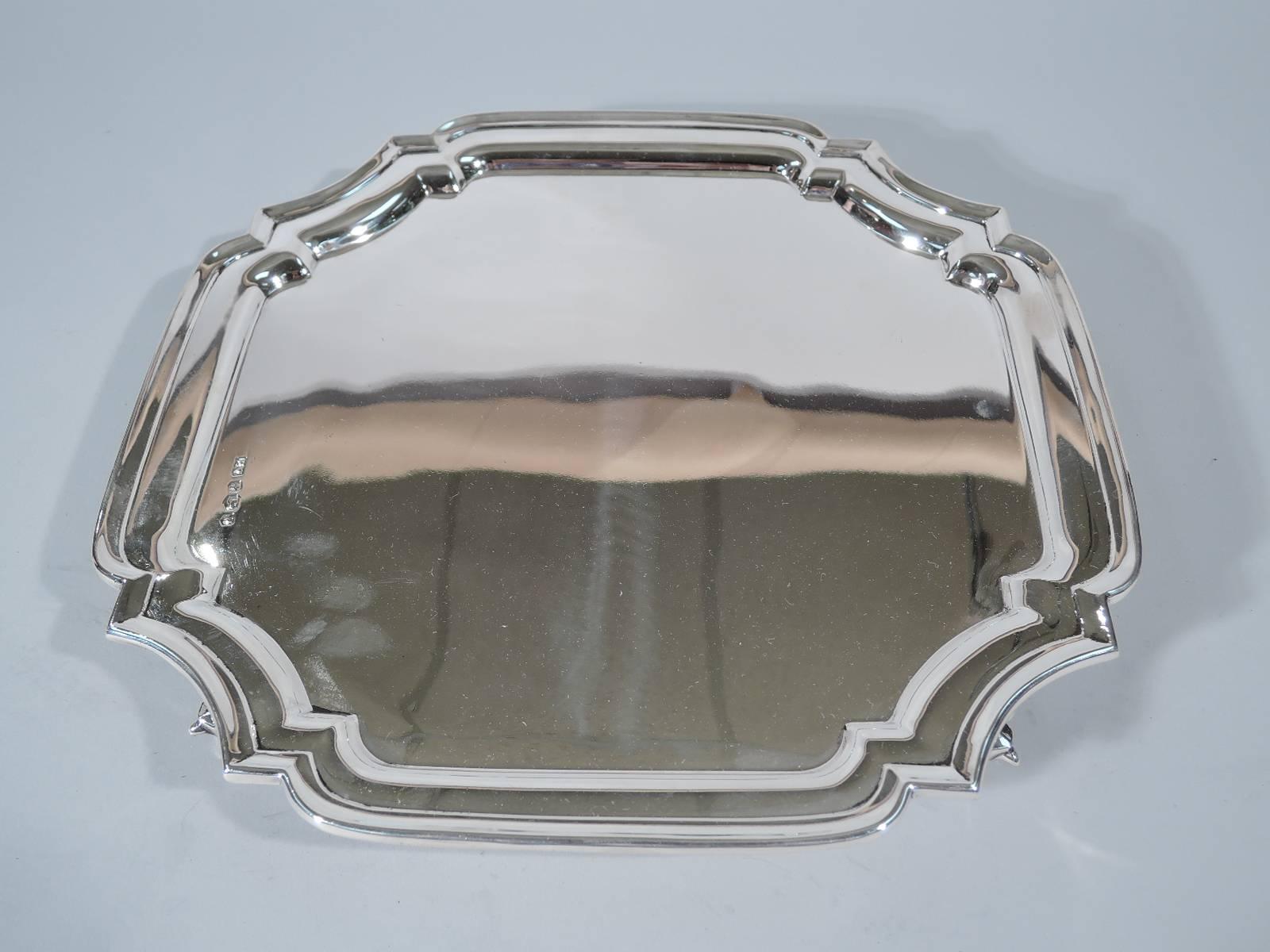 Traditional sterling silver salver tray. Made by Edward Viner in Sheffield in 1964. Four curved sides with concave corners and molded rim. Rests on four leaf-capped volute scrolls. Hallmarked. Very good condition.

Dimensions: H 1 1/4 x W 10 5/8 x