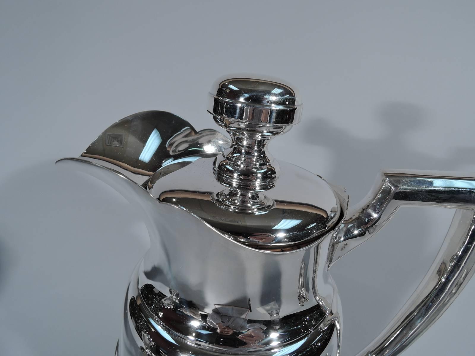 Sterling silver cocktail shaker. Made by Alvin (a division of Gorham) in Providence, circa 1930. Baluster body, skirted and scrolled foot, scroll bracket handle, and helmet mouth with scrolled rim. Cover has substantial cork plug. Hallmark includes