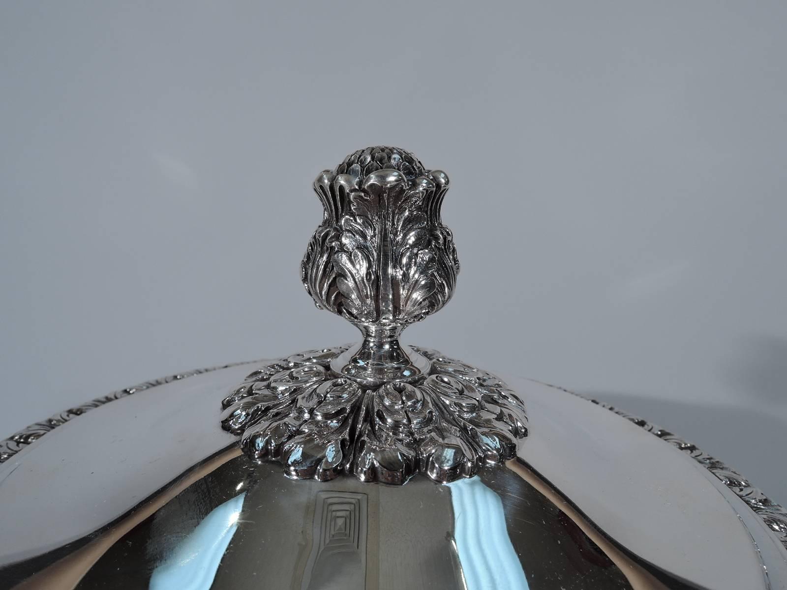 George V sterling silver covered trophy cup. Made by Mappin & Webb in Sheffield in 1932. Baluster body on short knopped stem on raised circular foot mounted to square base. Reeded bracket handles with leaf mounts. Chased leaves. Knop and foot