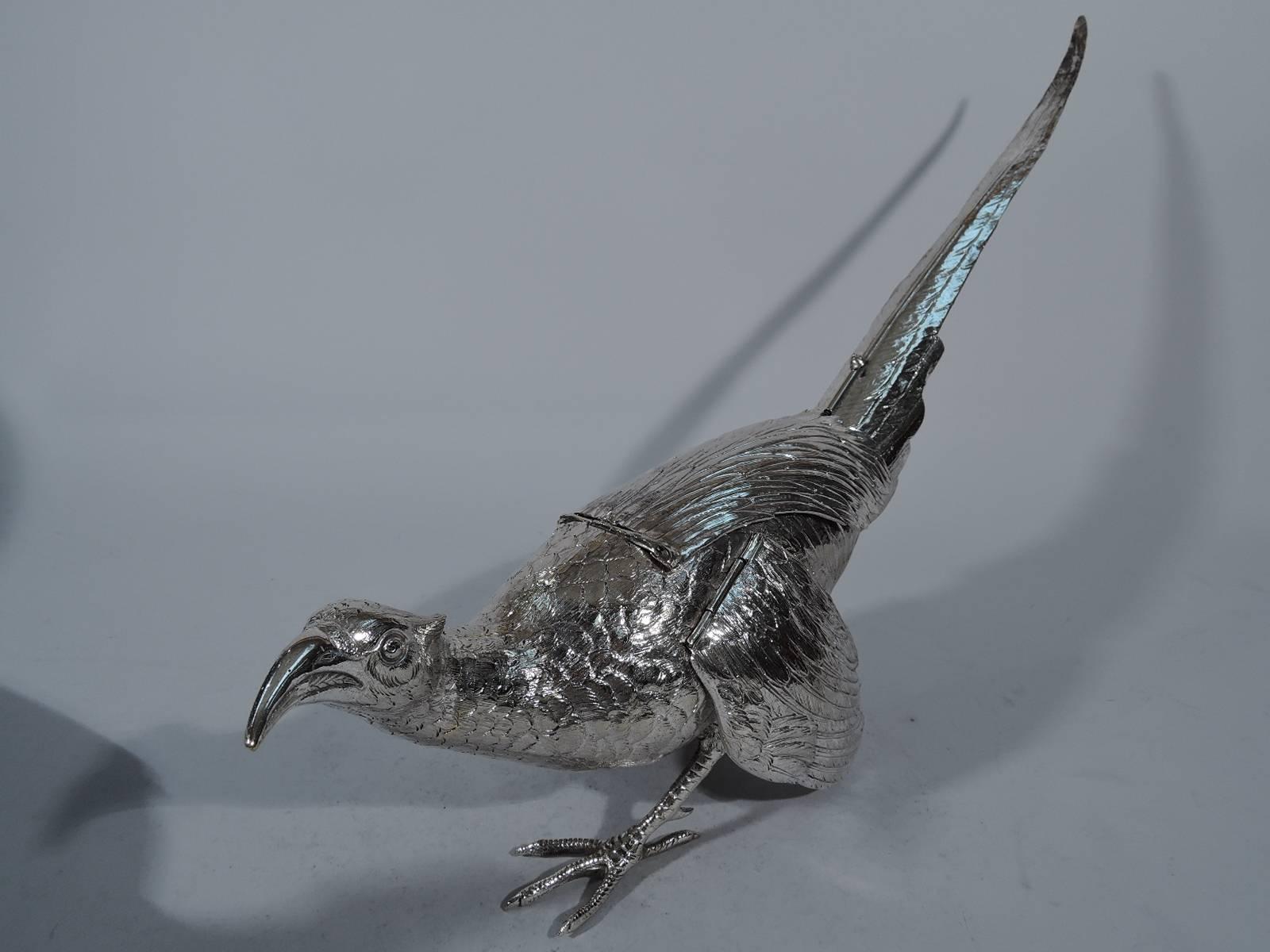 Pair of antique German sterling silver pheasants, circa 1910. Each: Erect and tilted head, raised tail, and scaly talons in full stride. Back has small compartment concealed by feather-form hinged cover. Wings also hinged, so the bird can fly away