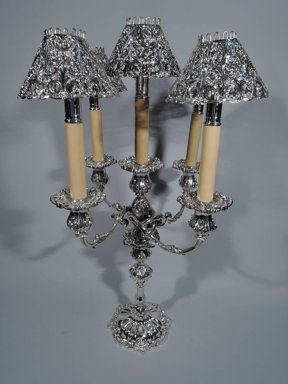 Pair of sterling silver five light candelabra. Made by JE Caldwell in Philadelphia, circa 1880. Each: baluster shaft on raised foot. Central raised light surrounded by four interlacing scrolled arms, each terminating in single light. Lots of dense