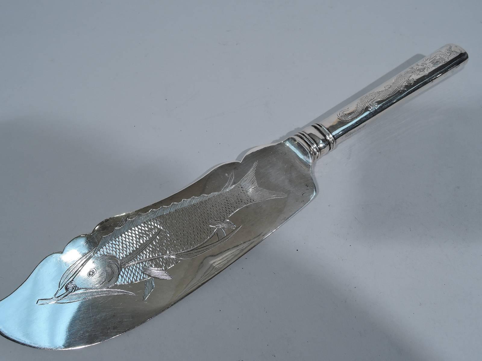 Chinese export silver fish serving pair, circa 1910. This pair comprises fork and slice. Both handles have engraved scary, scaly dragon. Both blade and shank have engraved depiction of dinner (that is, a fish). A fun special occasion set. Hallmark