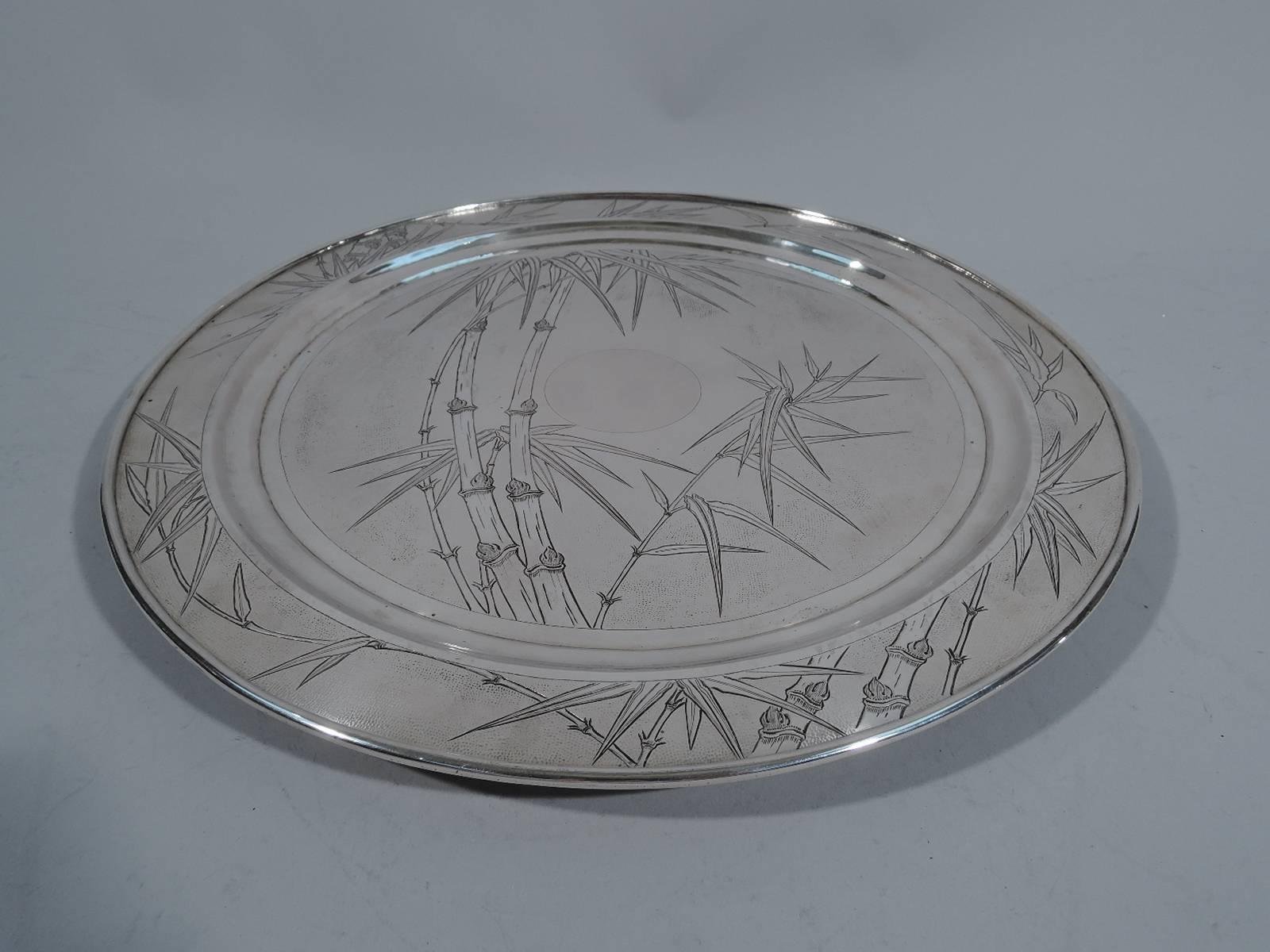 Chinese export silver salver, circa 1900. Circular. Stippled ground with engraved bamboo truncated by plain rim and well side. Central circular frame (vacant) also plain. A beautiful and restrained piece for serving and display. Rests on three
