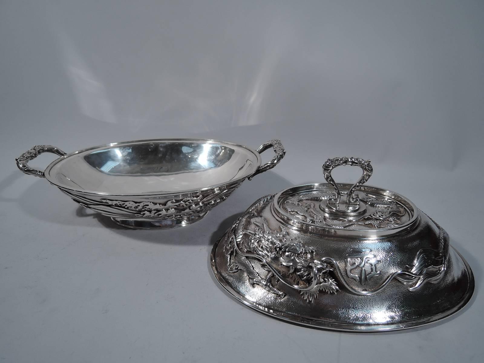 Large sterling silver tureen. Retailed by Arthur & Bond in Yokohama, circa 1900. Ovoid bowl with bracket end handles and spread oval foot. Domed cover with slip-lock bracket finial. Fine all-over honeycomb hand-hammering. Bowl has applied wraparound