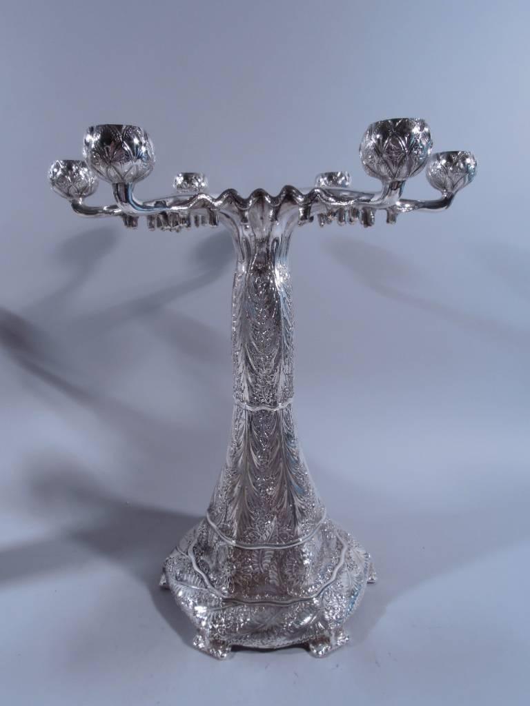 Pair of sterling silver Aesthetic-style six-light candelabra. Made by Tiffany & Co. in New York, late 20th century. Each: Six-point star with wavy rim, hatched and pointille fluting, and (on underside) short drops. Each point terminates in bowl