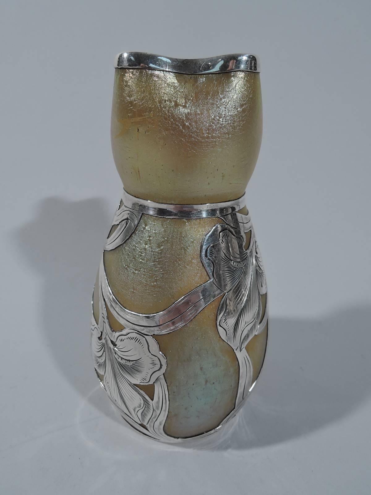 Art Nouveau iridescent glass vase with silver overlay. Made by Alvin in Providence, circa 1900. Oval body with curved neck and crimped quatrefoil mouth. Glass is shimmering gold. Overlaid silver flowers climb and wraparound the body. They are joined