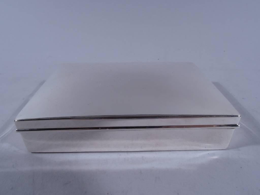 Sterling silver box. Made by Woods & Chatellier, circa 1910, for Tiffany & Co., both in New York. Rectangular with straight sides. Cover hinged and curved with molded rim. Maker’s and retailer’s marks as well as no. 204. Very good condition with