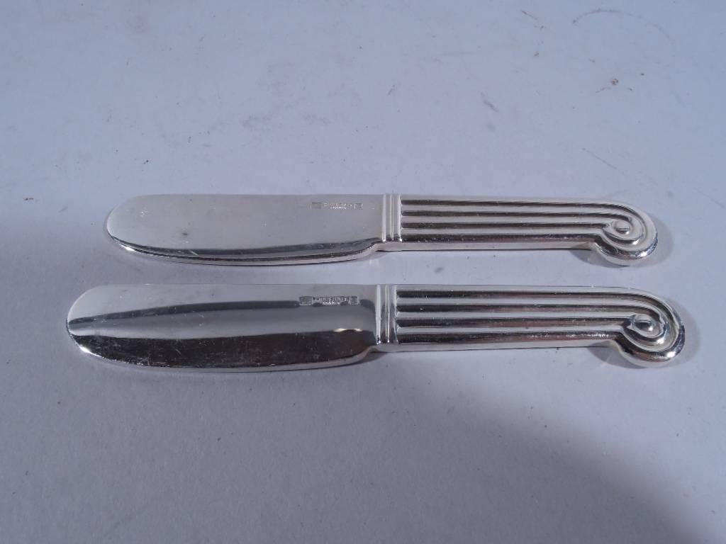 Set of eight silver plate pate knives. Made by Christofle in France. Each: fluted handle terminating in volute scroll. Ornament double-sided. Hallmarked blade. Condition good with minor surface wear.

Length: 3 7/8 in. BP201.