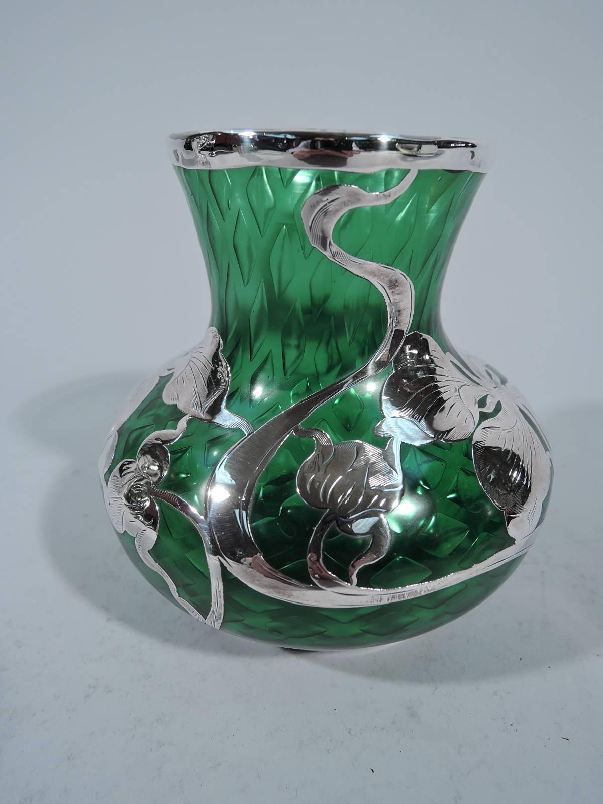 Art Nouveau quilted emerald glass vase with silver overlay. Made by La Pierre (later part of International) in Newark, circa 1900. Bellied bowl with short and gently tapering neck. Flowers and whiplash lines strewn over glass. Faint hallmark.