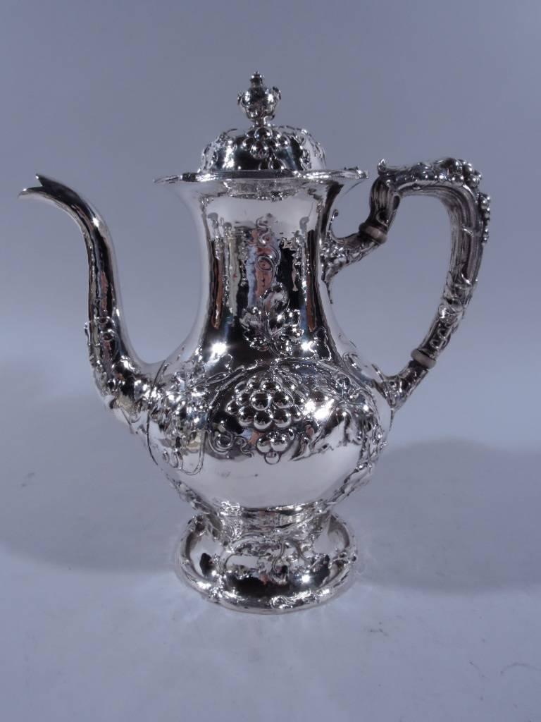 Hand-hammered sterling silver coffee and tea set. Made by Gorham in Providence, 1905-1910. This set comprises coffeepot, teapot, creamer, sugar, and waste bowl. Each: allover hand hammering with chased and repousse fruiting grapevine. Vine rims and