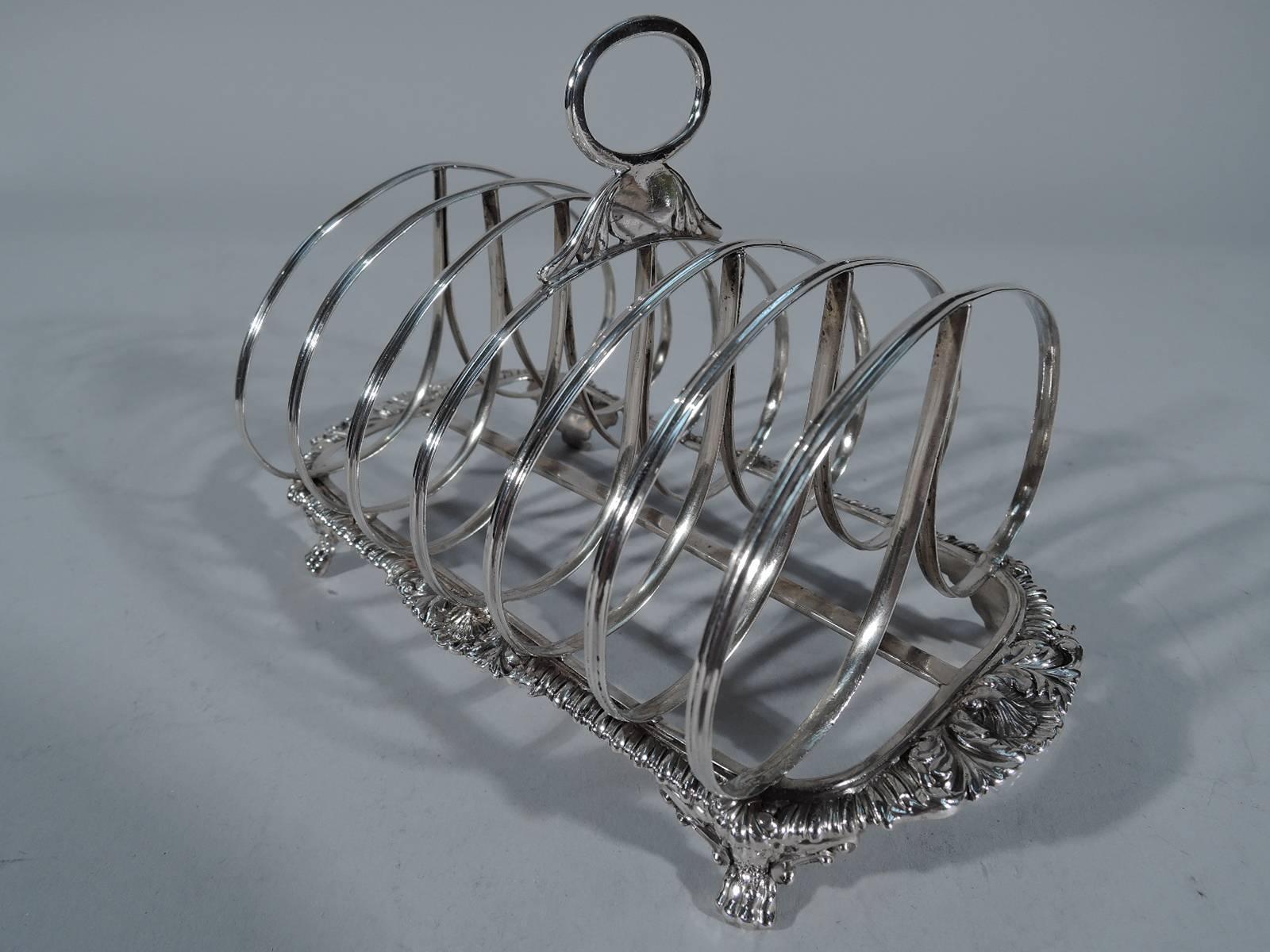 Beautiful quality sterling toast rack. Made in London in 1814. Six reeded double-loops with open oval handle on rectilinear frame. The frame is decorated with fine shells and gadroons, and rests on 4 paws. Worn marks though date letter and duty mark