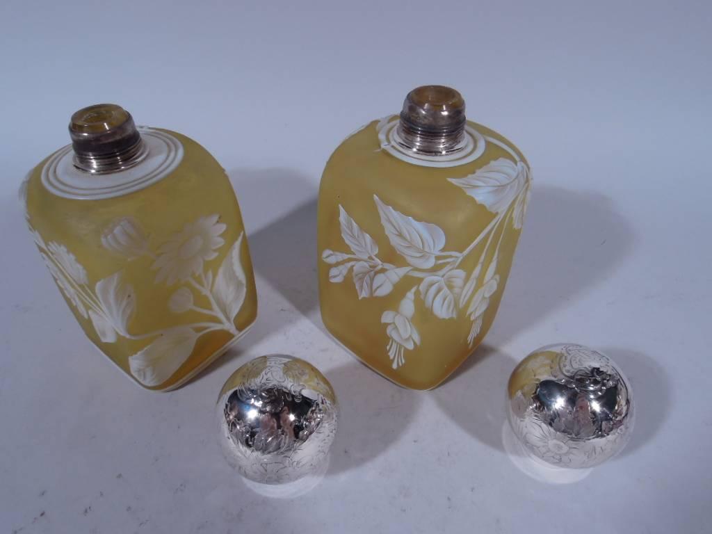 Pair of cameo art glass perfumes. Made by Thomas Webb in England, circa 1880. Each: Four straight sides with sloping shoulders and flat top. White Japonesque ornament on yellow ground. One perfume has flowers and ivy. The other perfume has flowers