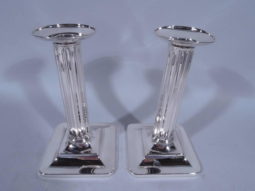 Pair of Classical sterling silver candlesticks. Made by Tiffany & Co. in New York, circa 1907. Each: fluted column on stepped square base. Detachable bobeche. Hallmark incudes pattern no. 17028 (first produced in 1907) and director’s letter M