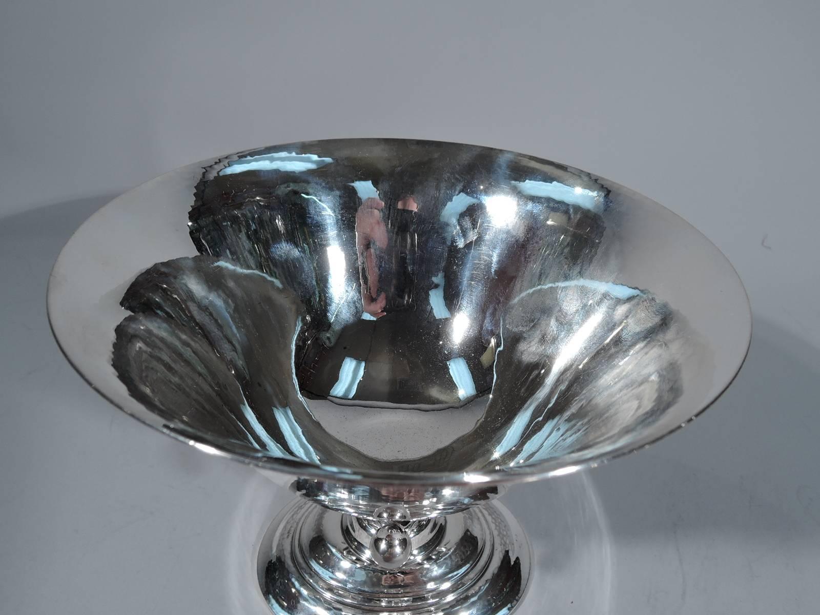 Sterling silver footed bowl. Made by Georg Jensen in Copenhagen. Round bowl with flared rim on open support on stepped oval foot. Support comprises tendril terminating in bead and mounted to leaf alternating with notched tendril. An abstract