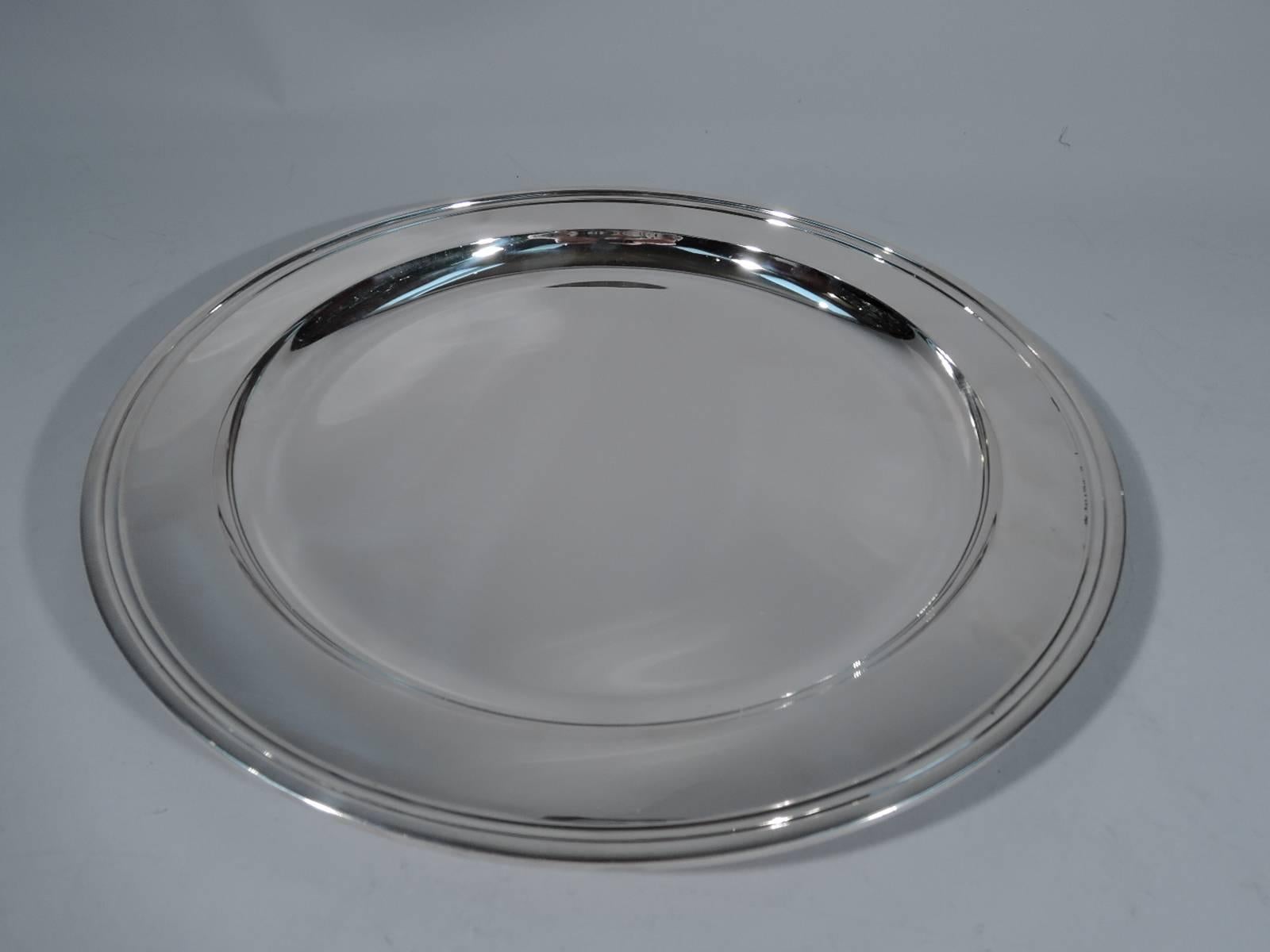 Deep and heavy sterling silver tray. Made by Tiffany & Co. in New York. Circular with applied and deep well. The pattern (no. 20188) was first produced in 1923. Hallmark includes director's letter M (1947-56). Excellent condition.

Dimensions: