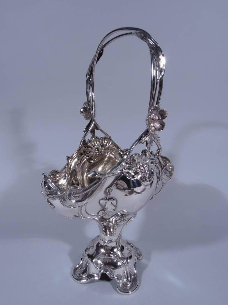 Austrian 800 silver basket, circa 1900. Bombe and ovoid body on wasted stem terminating in raised, pierced, and irregular quatrefoil foot. Stationary C-scroll handle in form of intertwined twigs and leaves. Period ornament including scrolls and