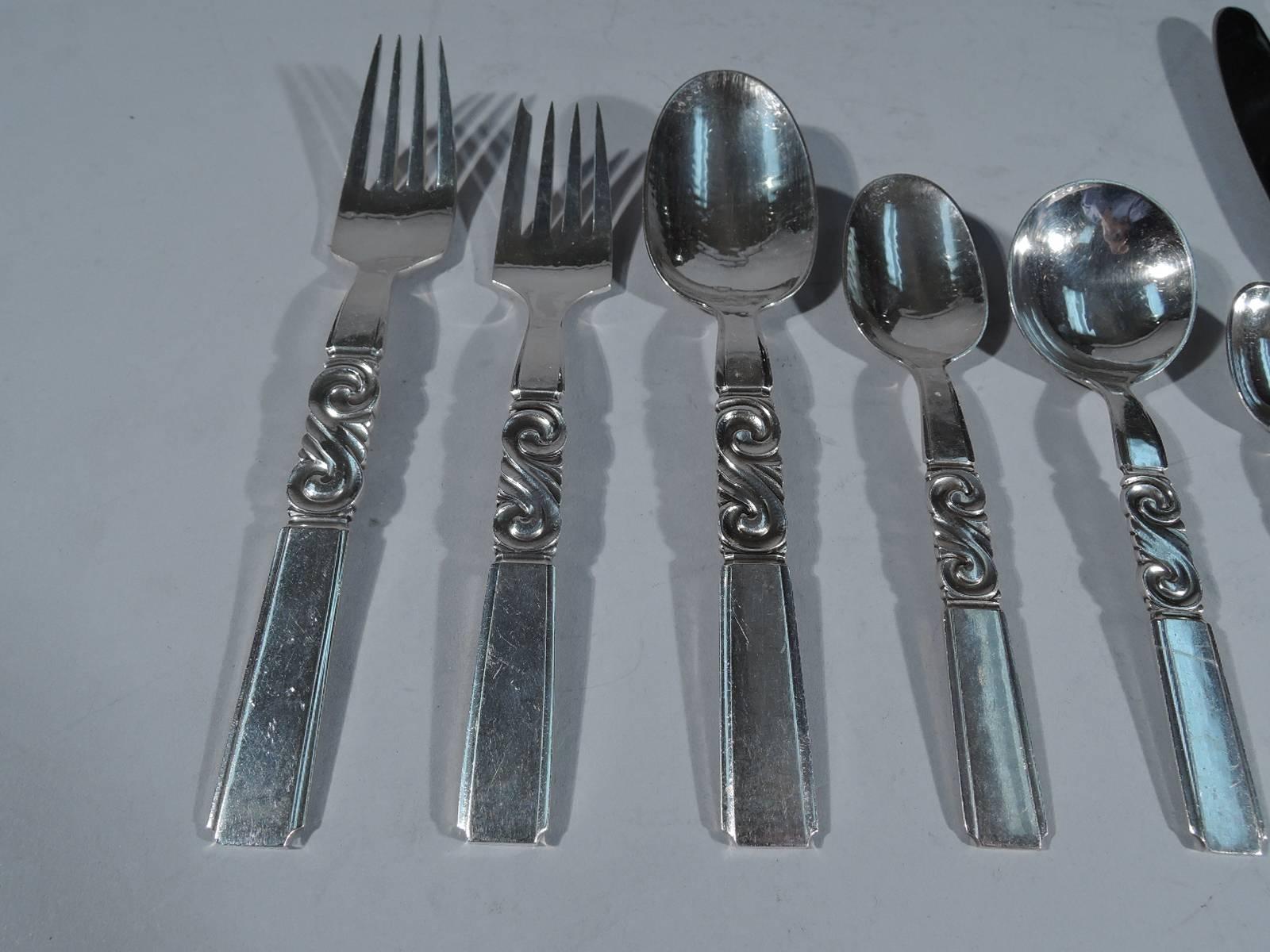 Sterling silver dinner service for 12 in Scroll pattern. Made by Georg Jensen in Copenhagen. This service comprises 90 pieces (all dimensions in inches): Forks: 12 dinner forks (7 1/8) and 12 salad forks (6 1/4); Spoons: Six dessert/soup spoons (6