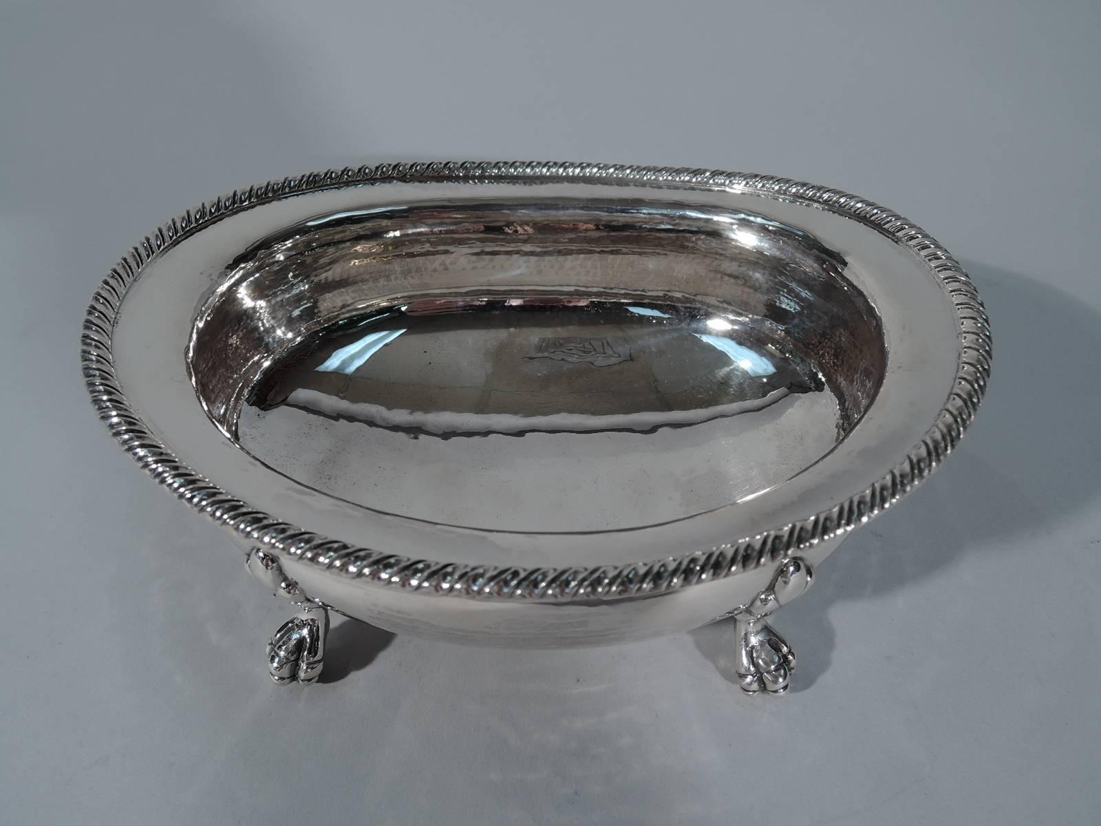 Hand-hammered sterling silver bowl. Made by Buccellati in Italy. Ovoid and bellied with gadrooned rim. Rests on four claw supports with stylized leaf mounts. Hallmarked. Very good condition. Dimensions: H 2 7/8 x W 6 1/2 x D 5 1/4 in. Weight: 11