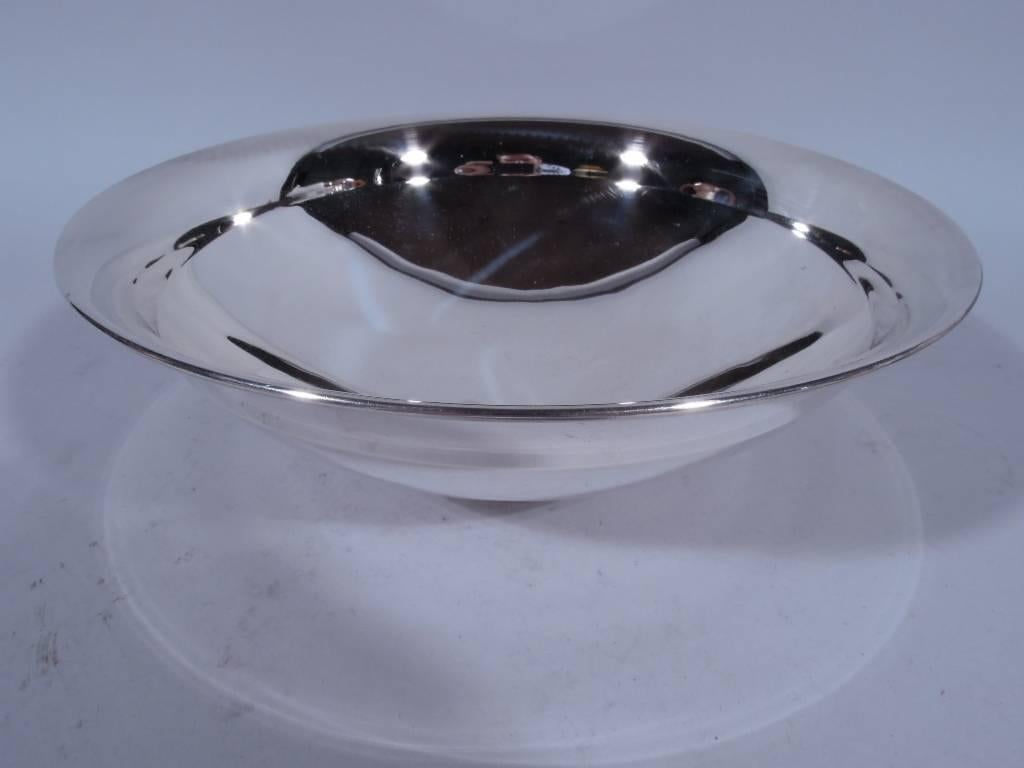 Modern sterling silver bowl. Made by Tiffany & Co. in New York, circa 1922. Shallow and curved with inset top and flared rim. Short foot. Hallmark includes pattern no. 20028 (first produced in 1922) and director’s letter m (1907-1947). Very good