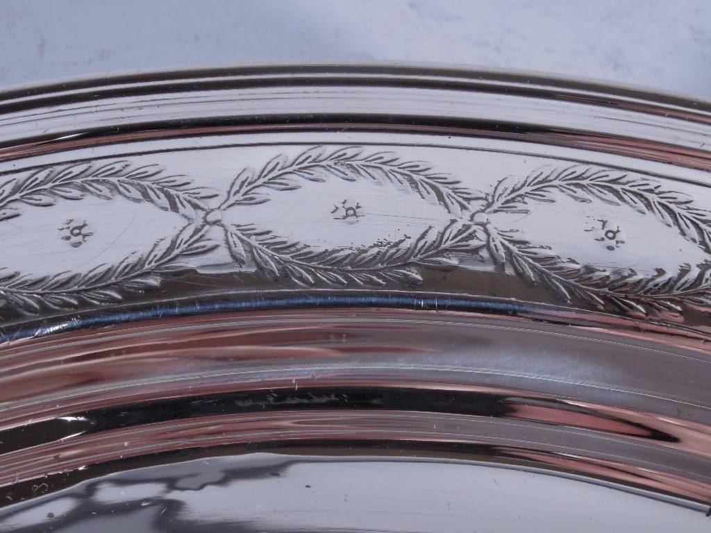 Sterling silver circular tray in Winthrop pattern. Made by Tiffany & Co. in New York, circa 1907. The Classic pattern: Interlace wreaths inset with blossom. Well has circular frame (vacant) radiating lines. Hallmark includes no. 16985H (first