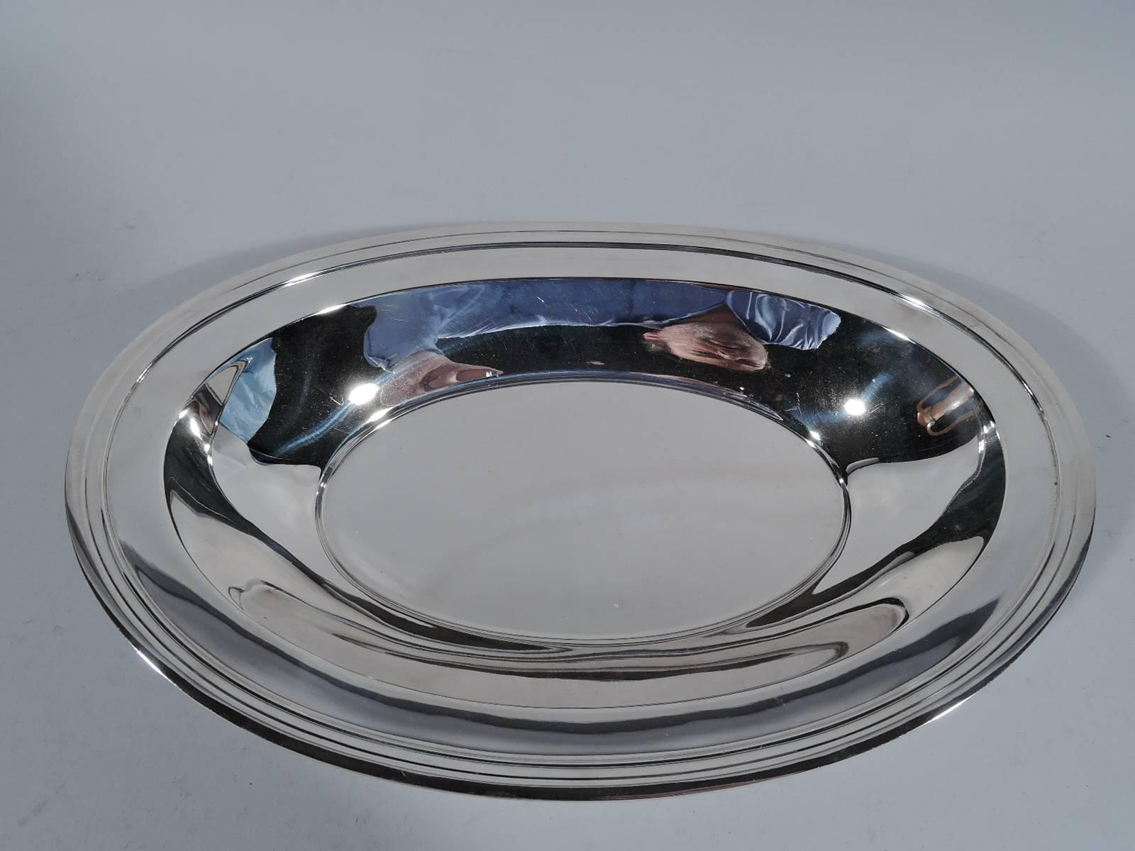 Modern sterling silver bread tray. Made by Tiffany & Co. in New York, circa 1925. Oval well, curved and tapering sides and asymmetrical rim. Hallmark includes pattern no. 20600 (first produced in 1925) and director’s letter m (1907-47). Very good