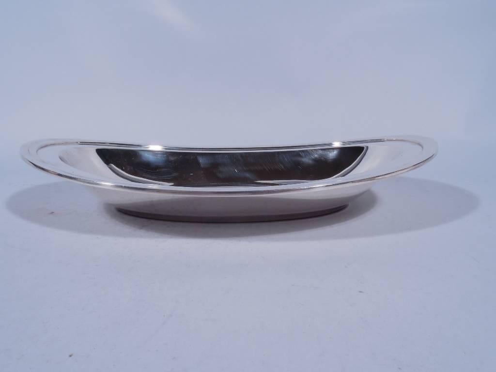 Modern sterling silver bread tray. Made by Tiffany & Co. in New York. Oval well, curved and tapering sides and asymmetrical rim. Hallmark includes pattern no. 20600, director’s letter m (1907-1947) and wartime star (1943-1945). Very good