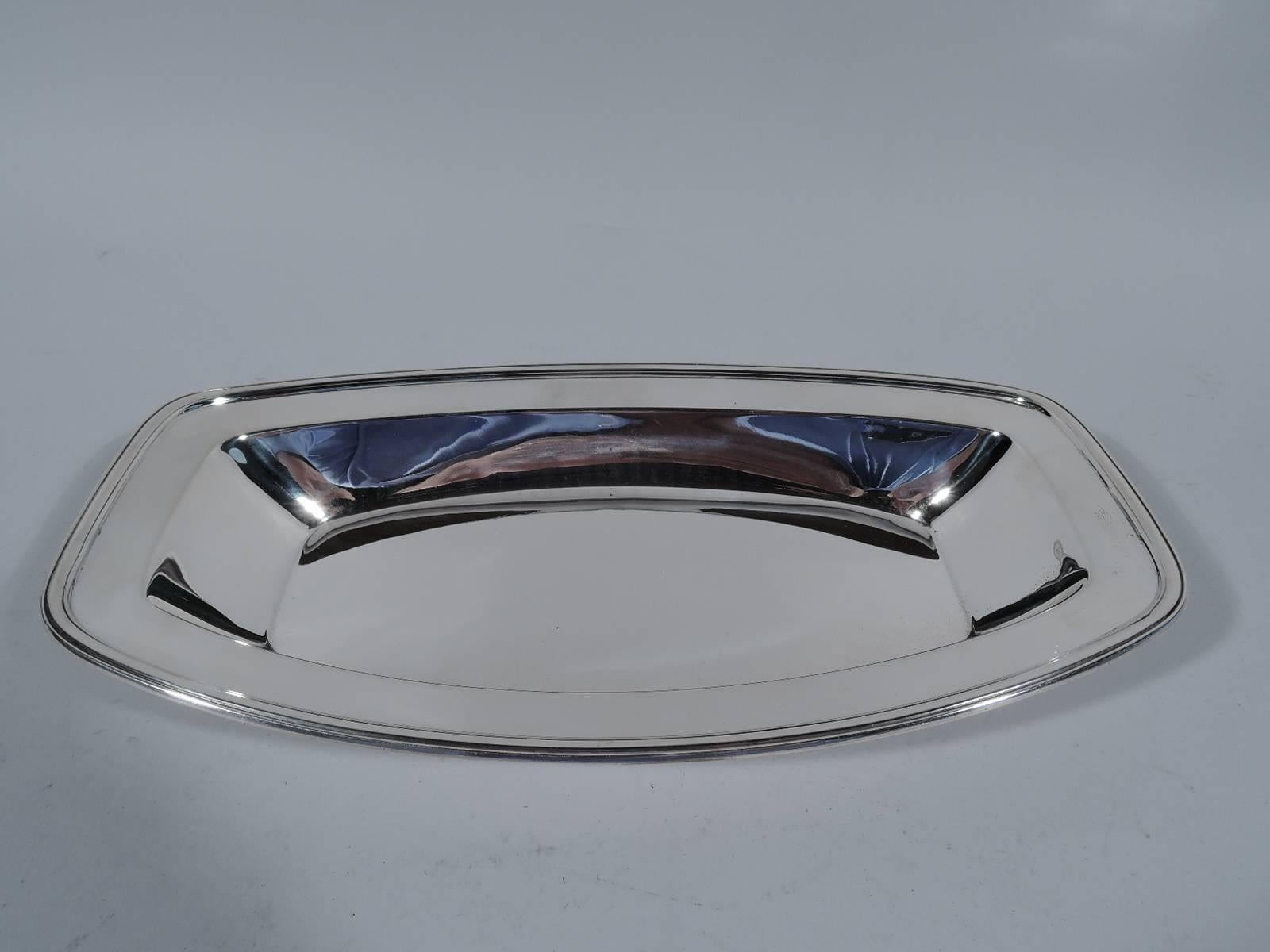 Smart sterling silver bread tray. Made by Tiffany & Co. in New York, circa 1927. Well has curved sides and truncated ends. Tapering sides with flat border and molded rim. Hallmark includes pattern no. 20942 (first produced in 1927) and director’s