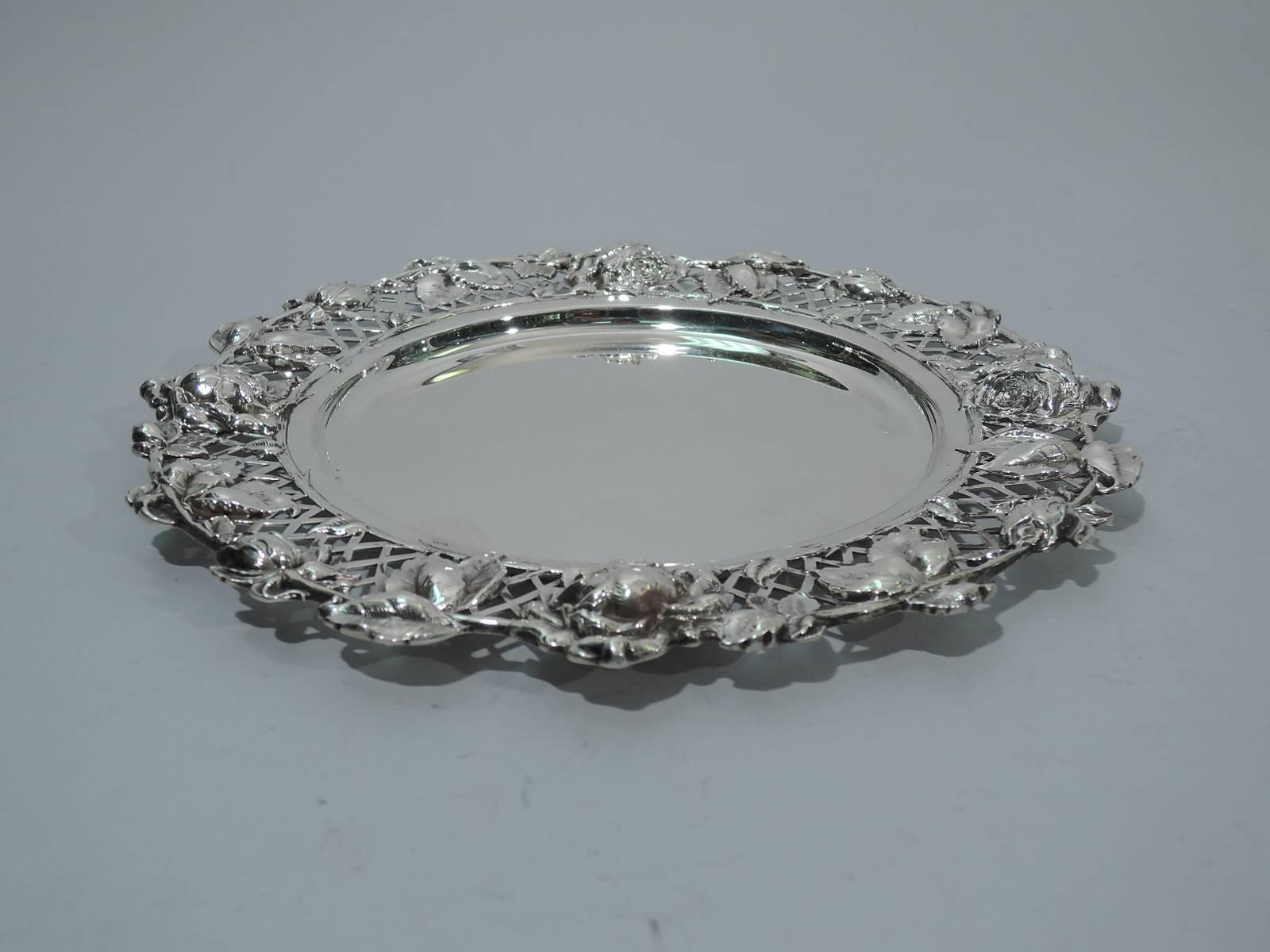 Set of ten sterling silver plates. Made by Redlich in New York, circa 1900. Each: solid well bordered by naturalistic roses, some buds, others bloomed, applied to trellis. Hallmark includes model no. 4676P. Excellent condition.

Dimensions: H 1/2