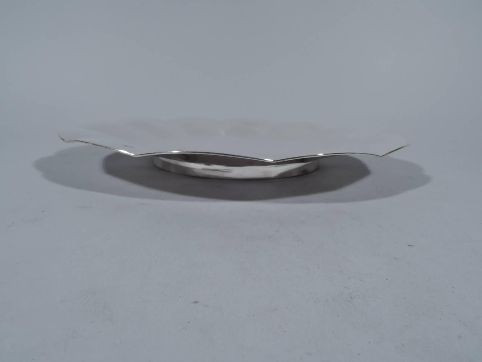 Modern sterling silver cake plate. Made by Tiffany & Co. in New York, circa 1940. Flat well and sloping sides with wide convex petals and shallow scalloping. Rests on short straight foot. Hallmark includes pattern no. 22929 (first produced in 1940)