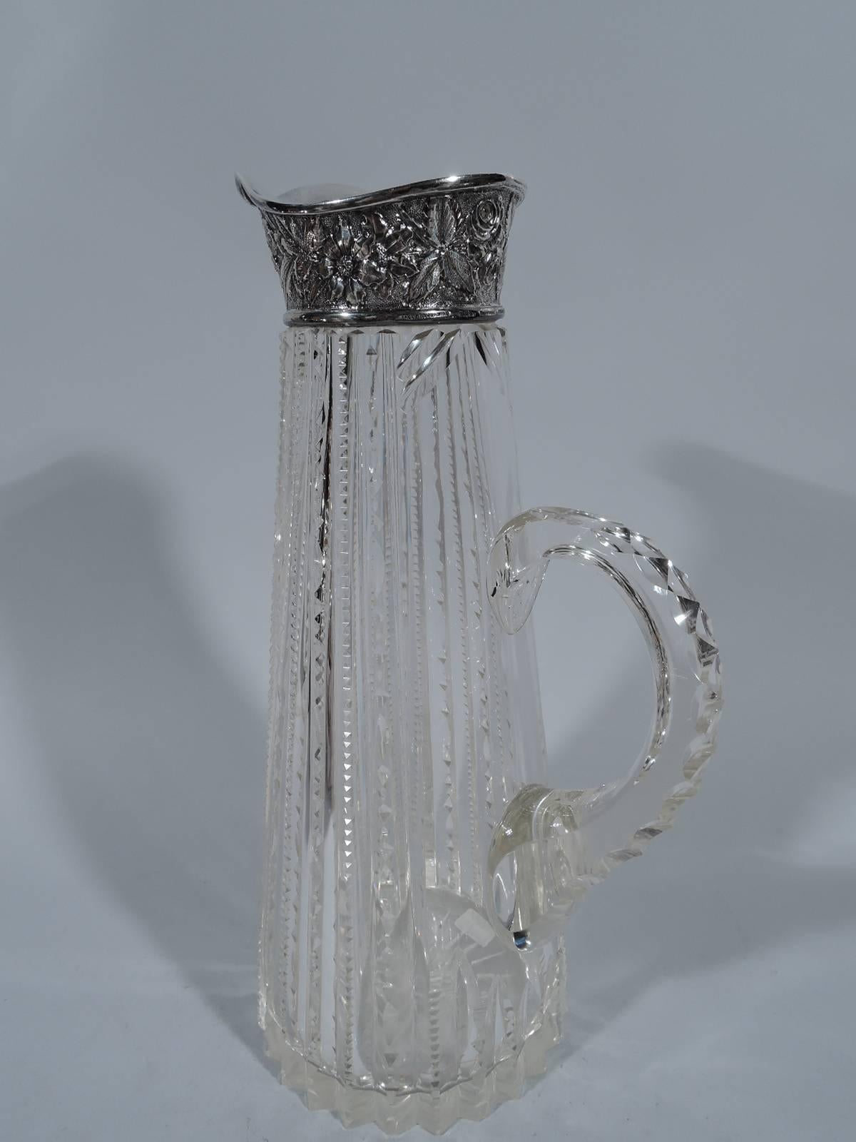 Brilliant-cut-glass and sterling silver claret jug. Made by Jacobi & Jenkins in Baltimore, circa 1900. Conical with geometric ornament and contrasting repousse silver collar. Faceted C-scroll handle. A beautiful combination of technique and texture.
