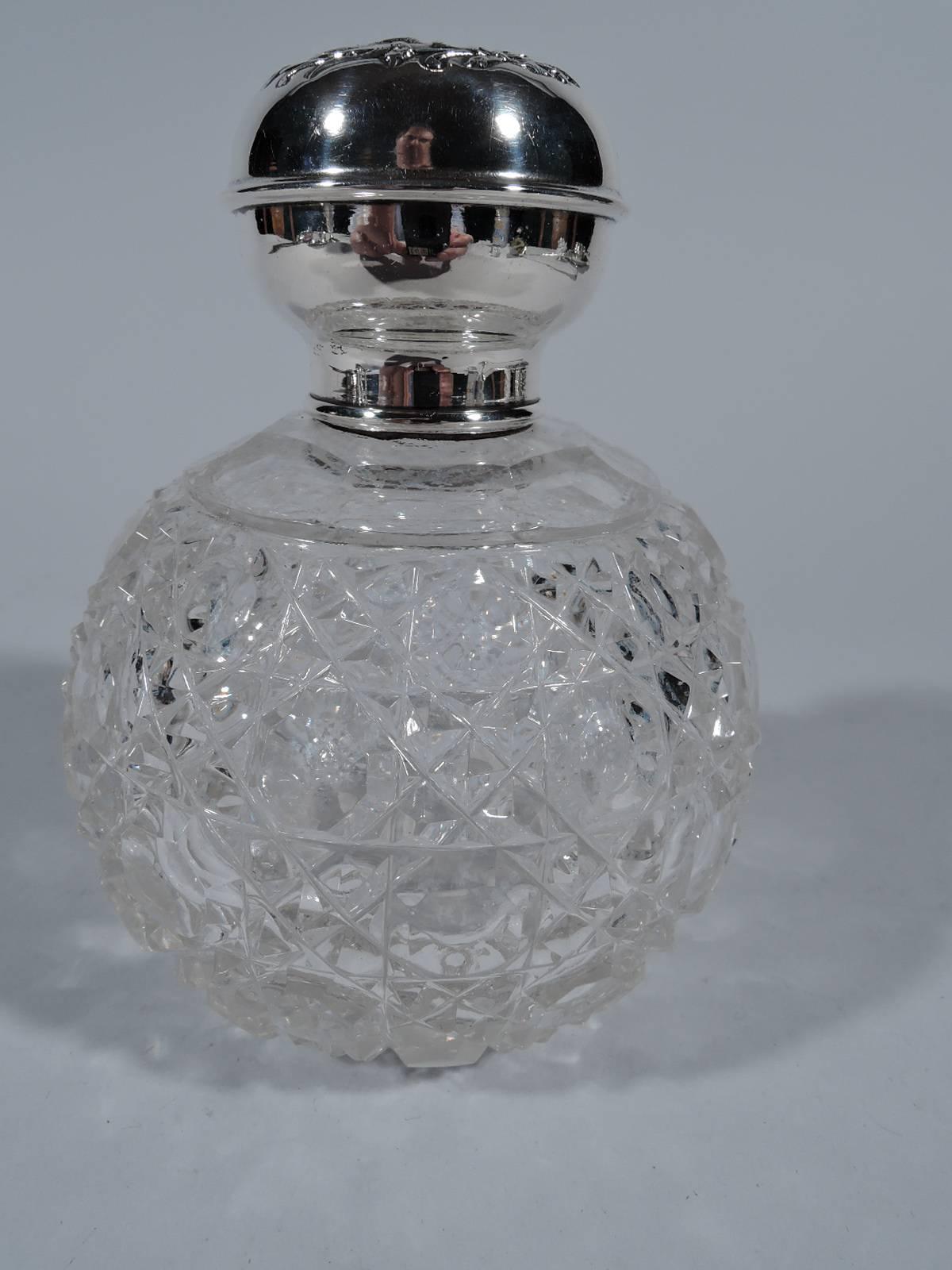 Edwardian sterling silver and cut-glass perfume. Made in Birmingham, England in 1904. Globular glass body with cut diaper pattern. Short neck in silver collar and faceted glass stopper with short plug. Silver ball cover with winged cherubs’ heads in