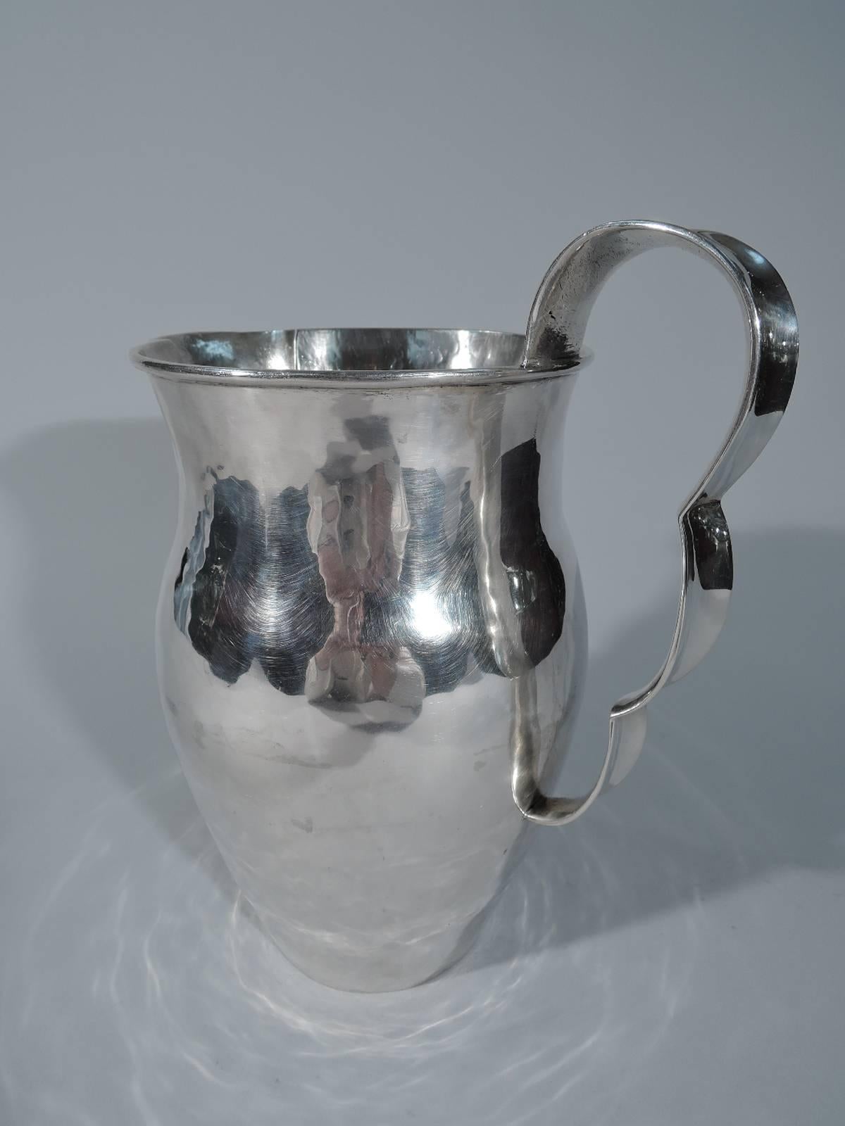 Modern sterling silver water pitcher. Made by Spratling in Mexico. Elongated baluster body with high-looping ribbon handle. Bell-form spout terminating in bead. Visible hand hammering. A great piece by this maker. Hallmarked (ca 1940-44). Weight: 30