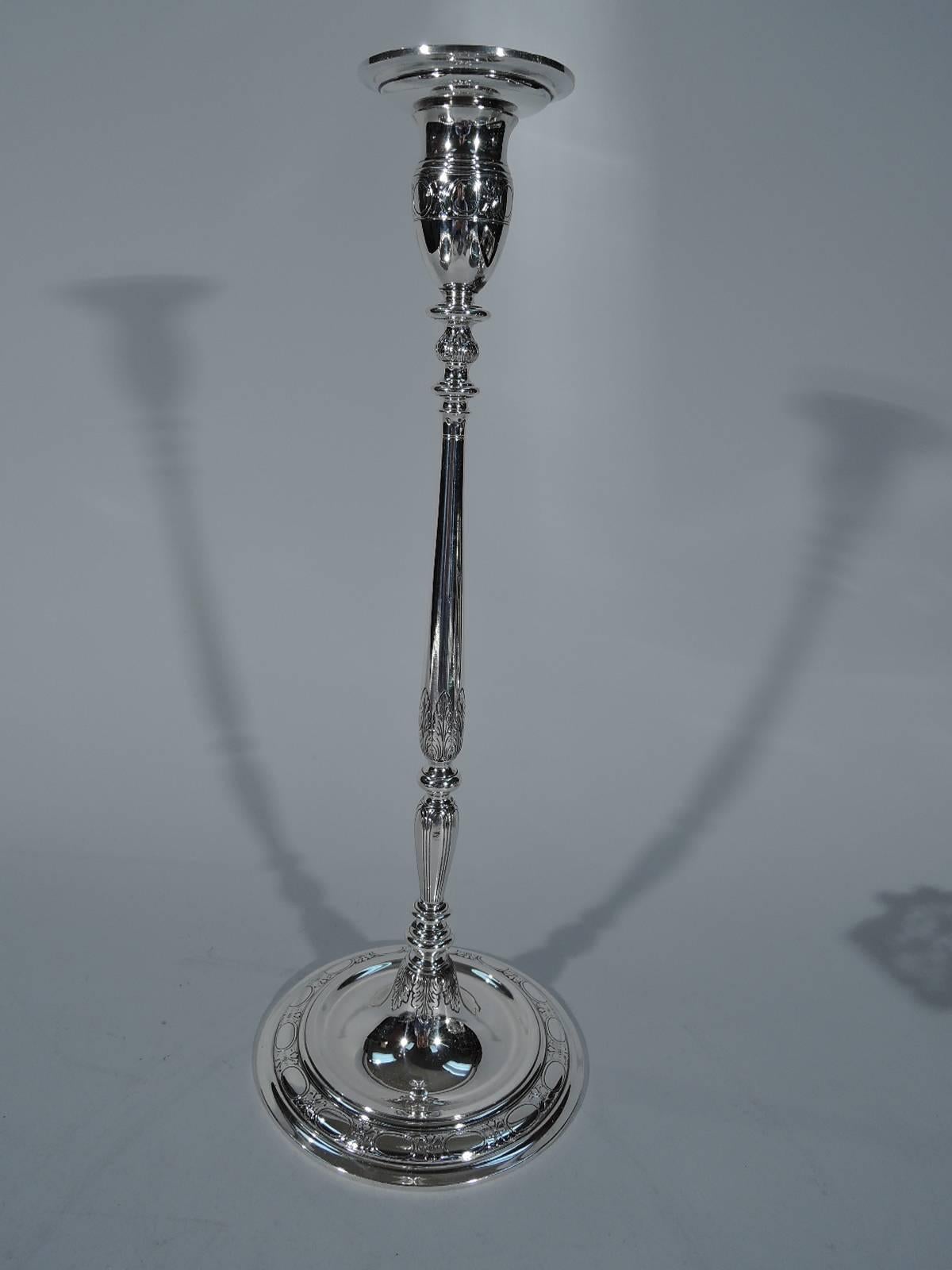 Pair of Modern sterling silver candlesticks. Made by Tiffany & Co. in New York, circa 1925. Each: Unusual attenuated form with knopped double baluster shaft on domed foot. Oval socket with detachable bobeche. Leaves and bands of stylized flowers