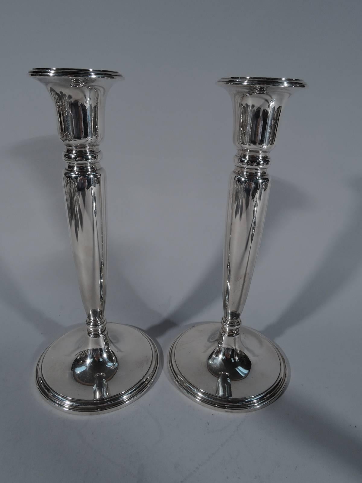 Set of four modern sterling silver candlesticks. Made by Tiffany & Co. in New York. Each: Tapering shaft terminating in knop on raised foot. Shaft top has knop surmounted by urn socket with stepped rim. Hallmark includes pattern no. 20762 and