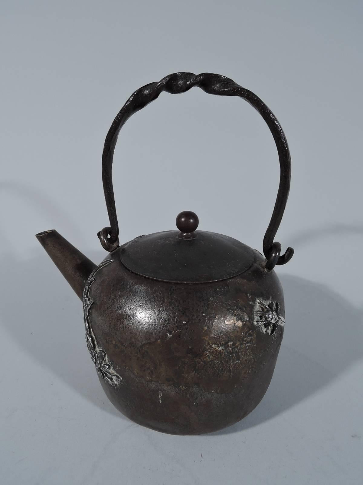 Japonesque iron teapot with sterling silver mounts. Made by Gorham in Providence in 1883. A rare experimental piece. Japanese form with cover and twisted swing handle. Iron surface is granulated with nuanced patina. Mounts are bird, blossoming