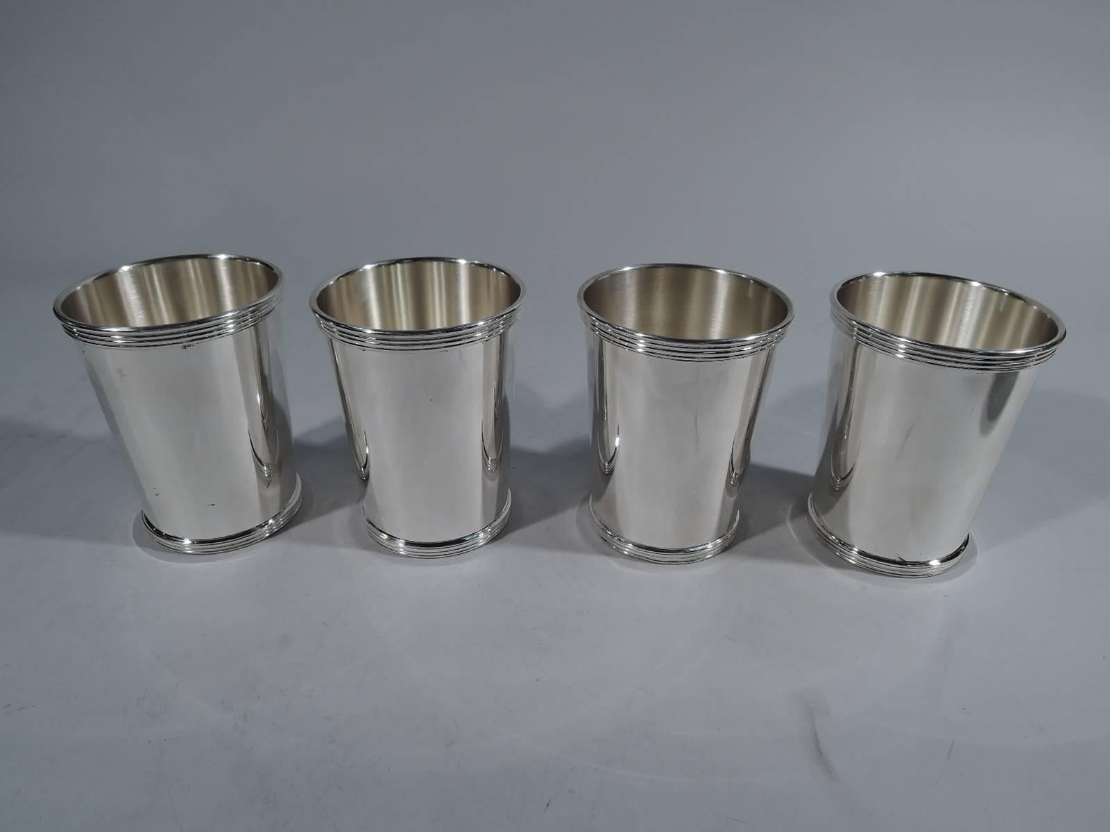 Set of four sterling silver mint julep cups. Made by International in Meriden, Conn. Straight and tapering sides. Reeded rim and base. A nice starter set. Hallmark includes pattern no. 10125/1. Total weight: 16 troy ounces.