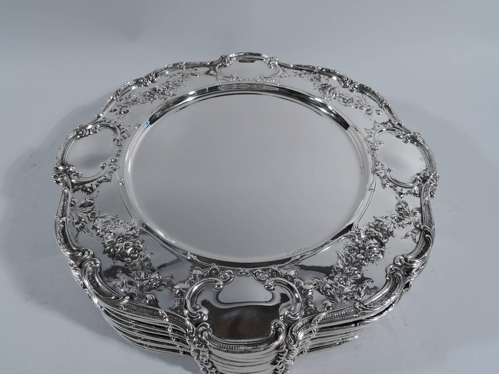 Set of 12 Edwardian sterling silver dinner plates. Made by Gorham in Providence in 1914. Each: plain well. On shoulder 4 scrolled cartouches (vacant) joined by floral garlands. Scrolled rim. Hallmark includes no. A6620 and date symbol. Total weight: