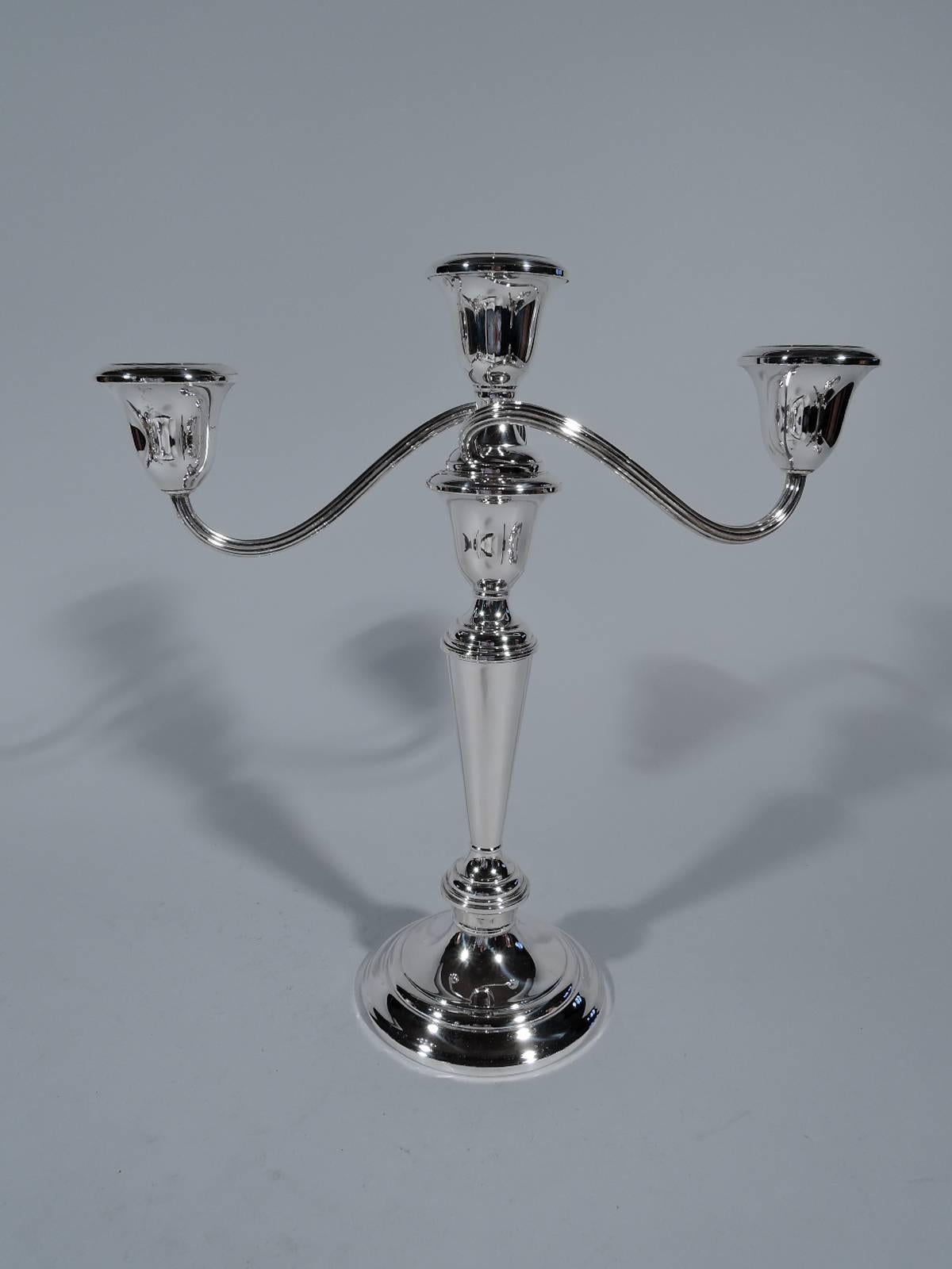 Pair of sterling silver three-light candelabra. Made by Gorham in Providence. Each: tapering columnar shaft and stepped foot. Central light with two reeded arms, each terminating in single light. Can be converted to candlesticks and low candelabra.