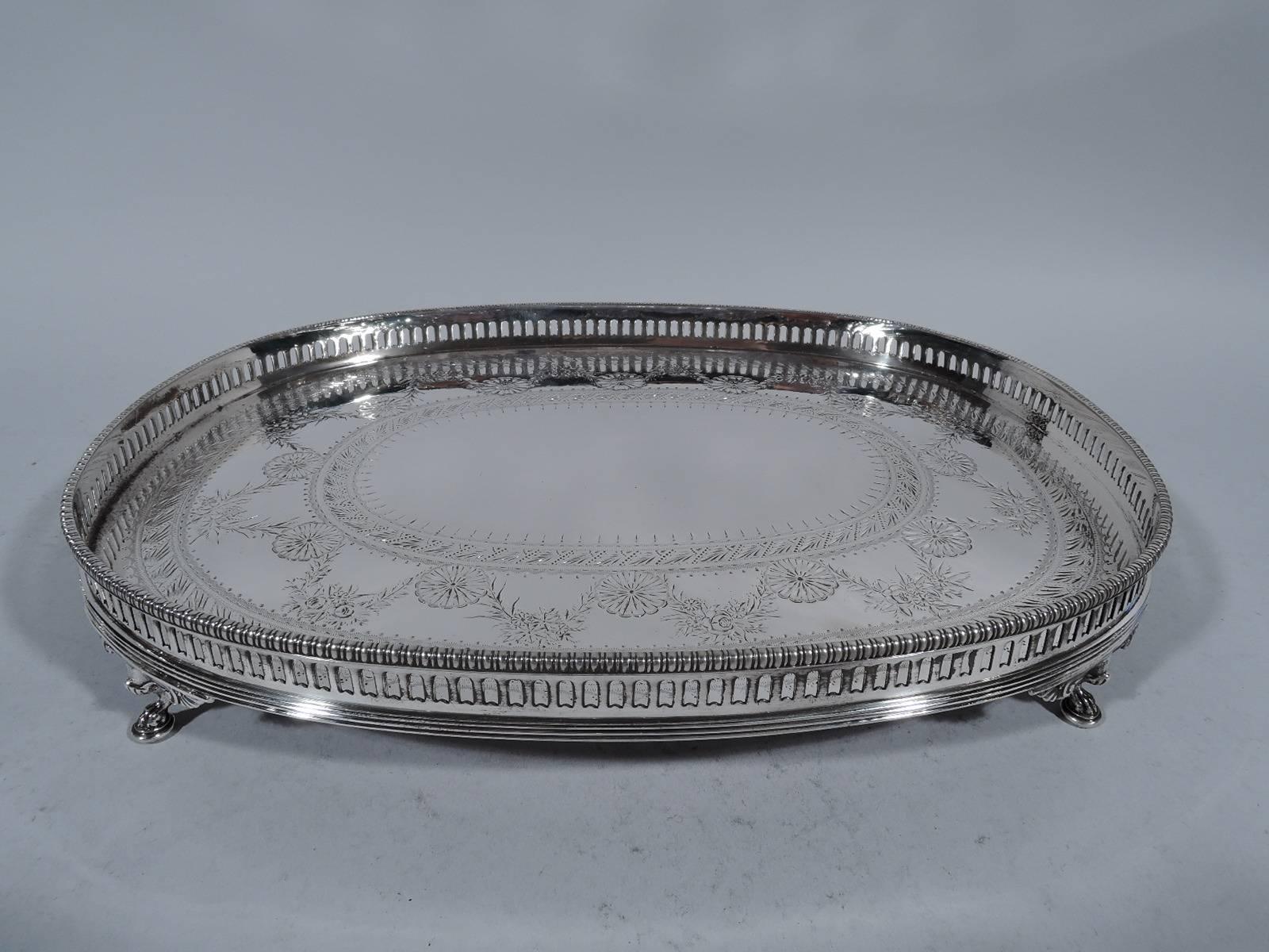 Unusual sterling silver salver. Made by Gorham in Providence in 1879. Oval well with engraved neoclassical ornament. Pierced gallery has bead-and-reel rim. Reeded base. Rests on four claw supports. Hallmark includes indistinct date letter (appears