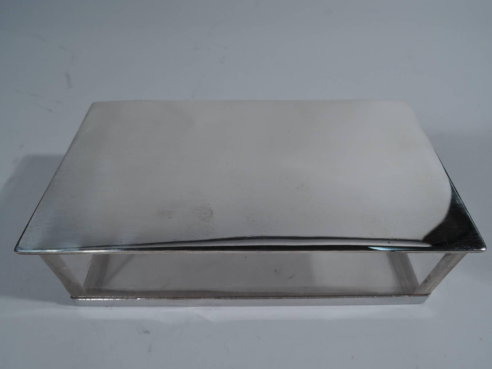 Experimental box. Made by Hawkes in Corning, circa 1920. Straight clear sides and bottom in Lucite (that is, acrylic glass) set in sterling silver frame. Cover also silver; it is hinged, flat, and slightly overhanging. An unusual piece by this