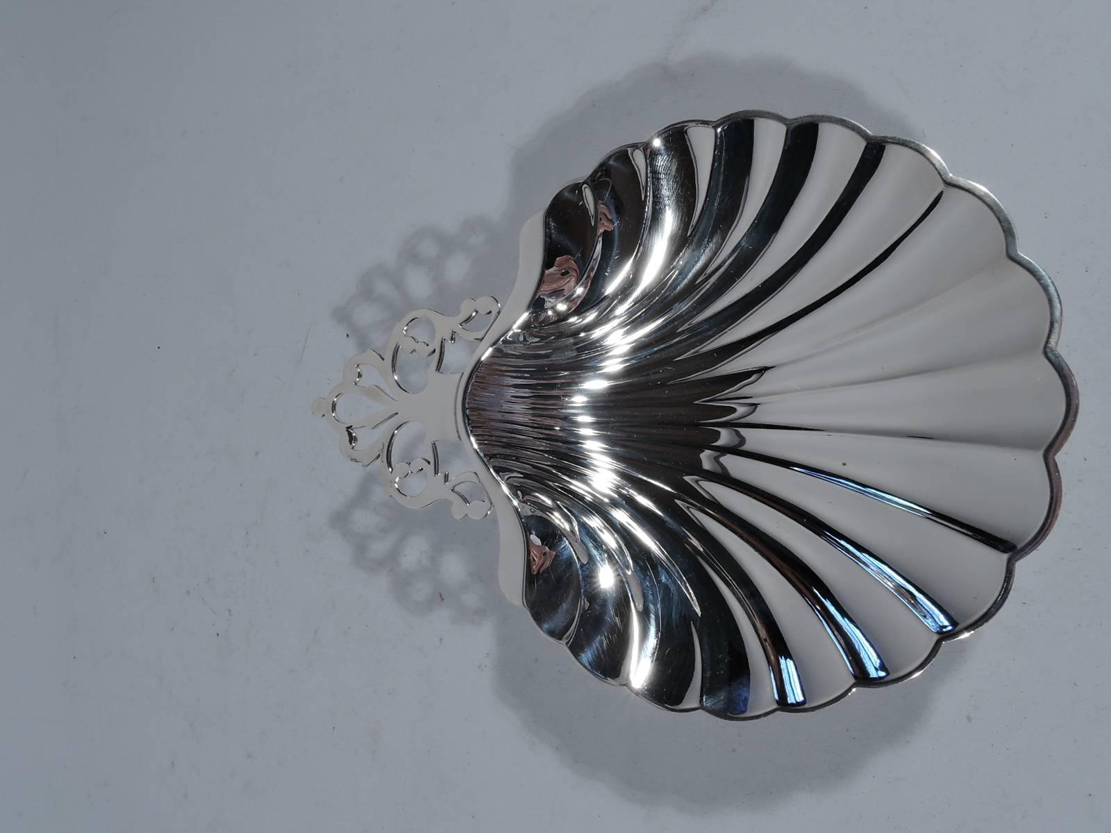 Sterling silver scallop shell. Made by Meriden Britannia (part of International) in Connecticut. Dynamic flutes and old-fashioned open tree handle. Hallmark includes no. WB141 and retailer’s name, Black, Starr, Frost-Gorham, which operated under