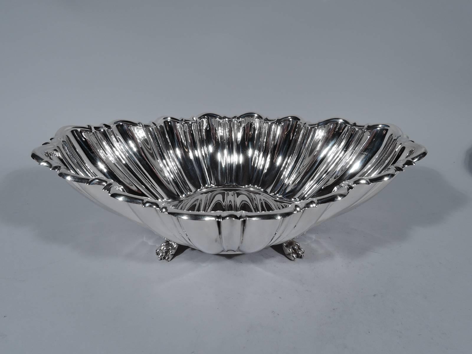 Modern classical sterling silver centerpiece bowl. Made by Reed & Barton in Taunton, Mass. in 1954. Quatrefoil well. Curved sides with alternating flutes and lobes. Scrolled rim. Rests on four paw supports with palmette mounts. A great revving up of