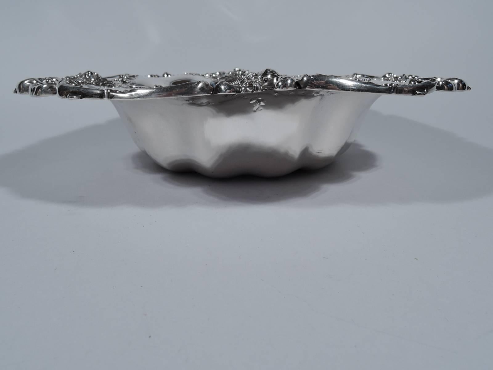 Pretty sterling silver bowl. Made by Bailey, Banks & Biddle in Philadelphia, ca 1900. Lobed well. Flat rim with floral garlands and scrolls. Hallmark includes no. 4258E. Measures: Weight 17.4 troy ounces.